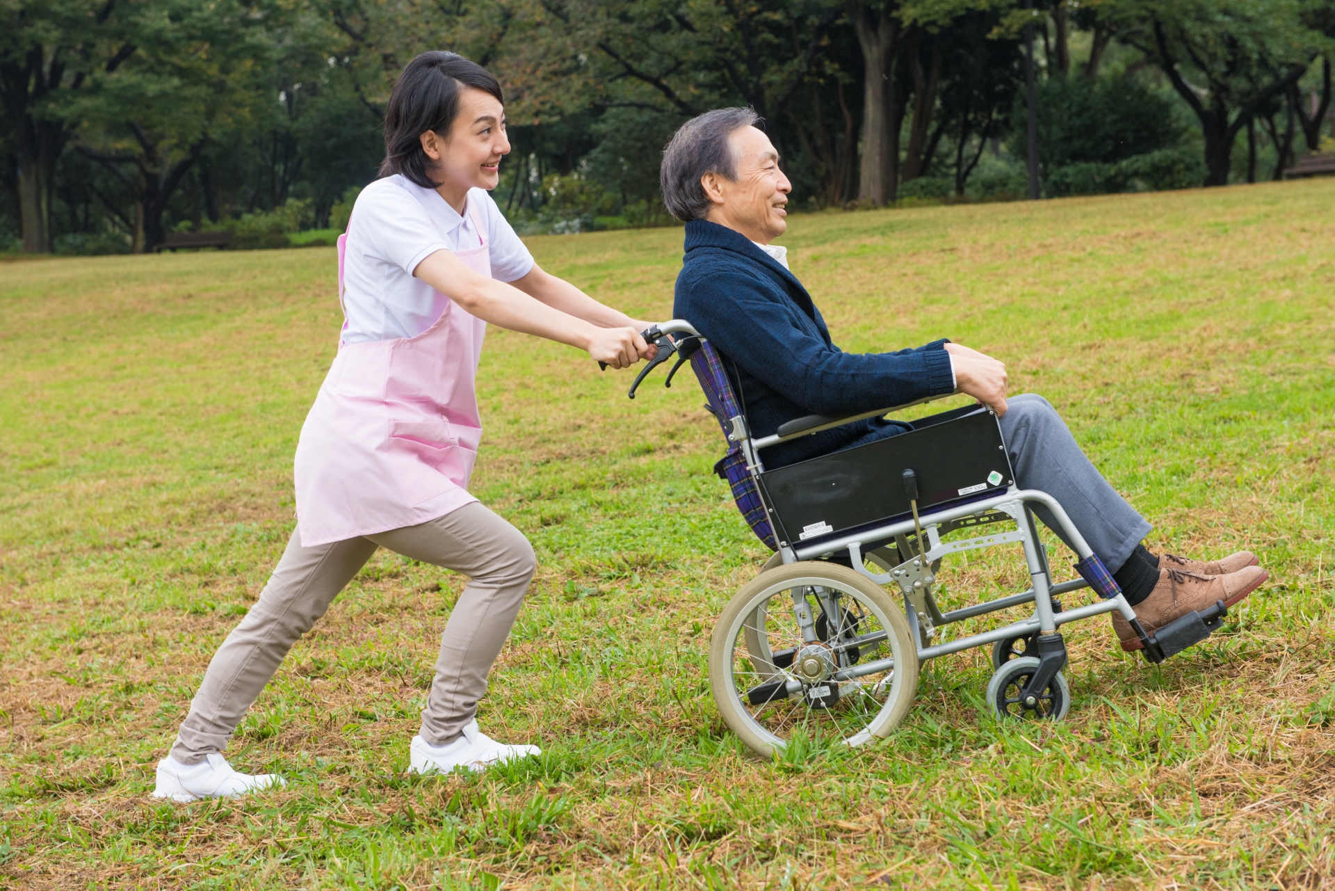 屋外の車椅子の男性と介護士