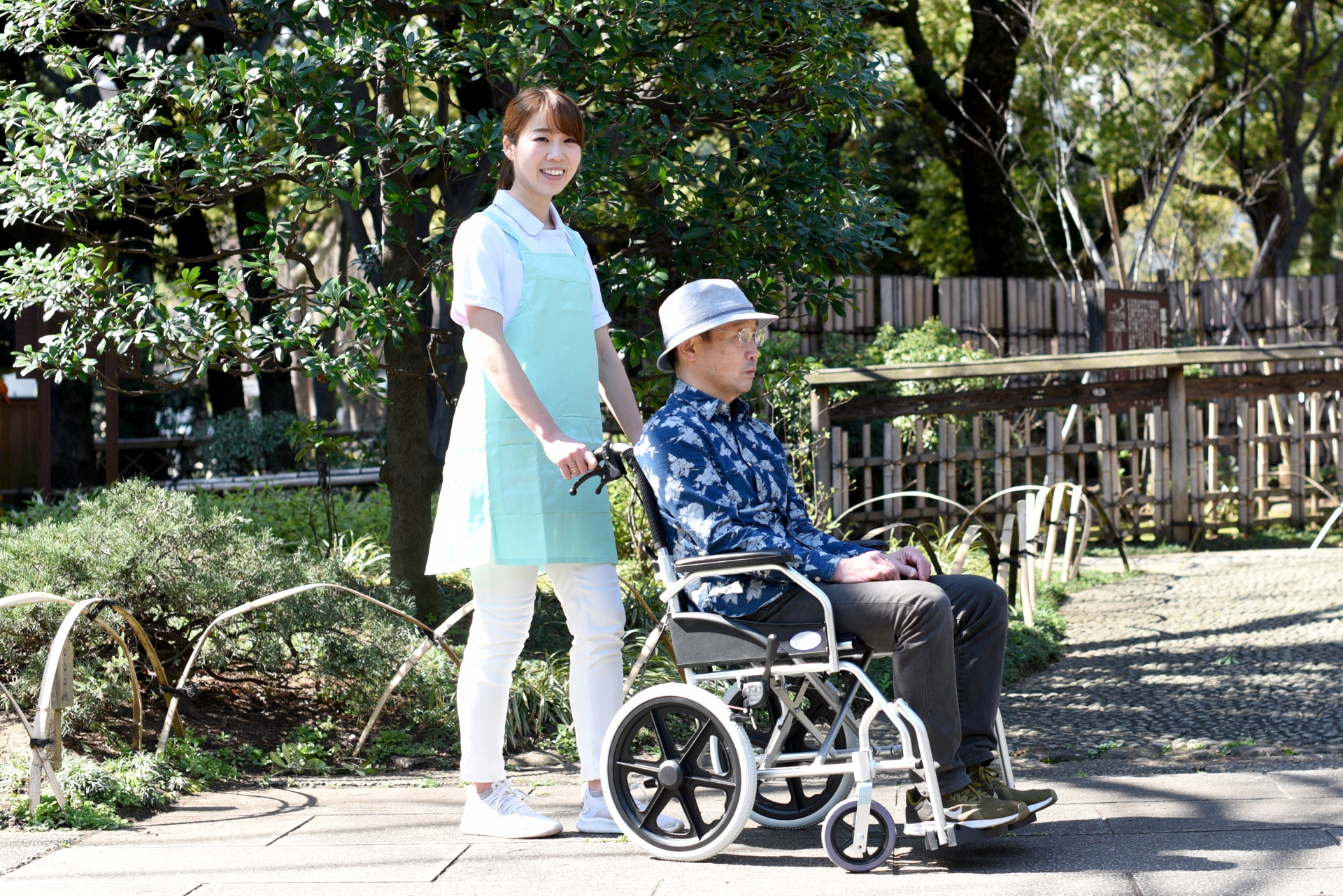 介護ヘルパーの女性と車椅子のシニア男性