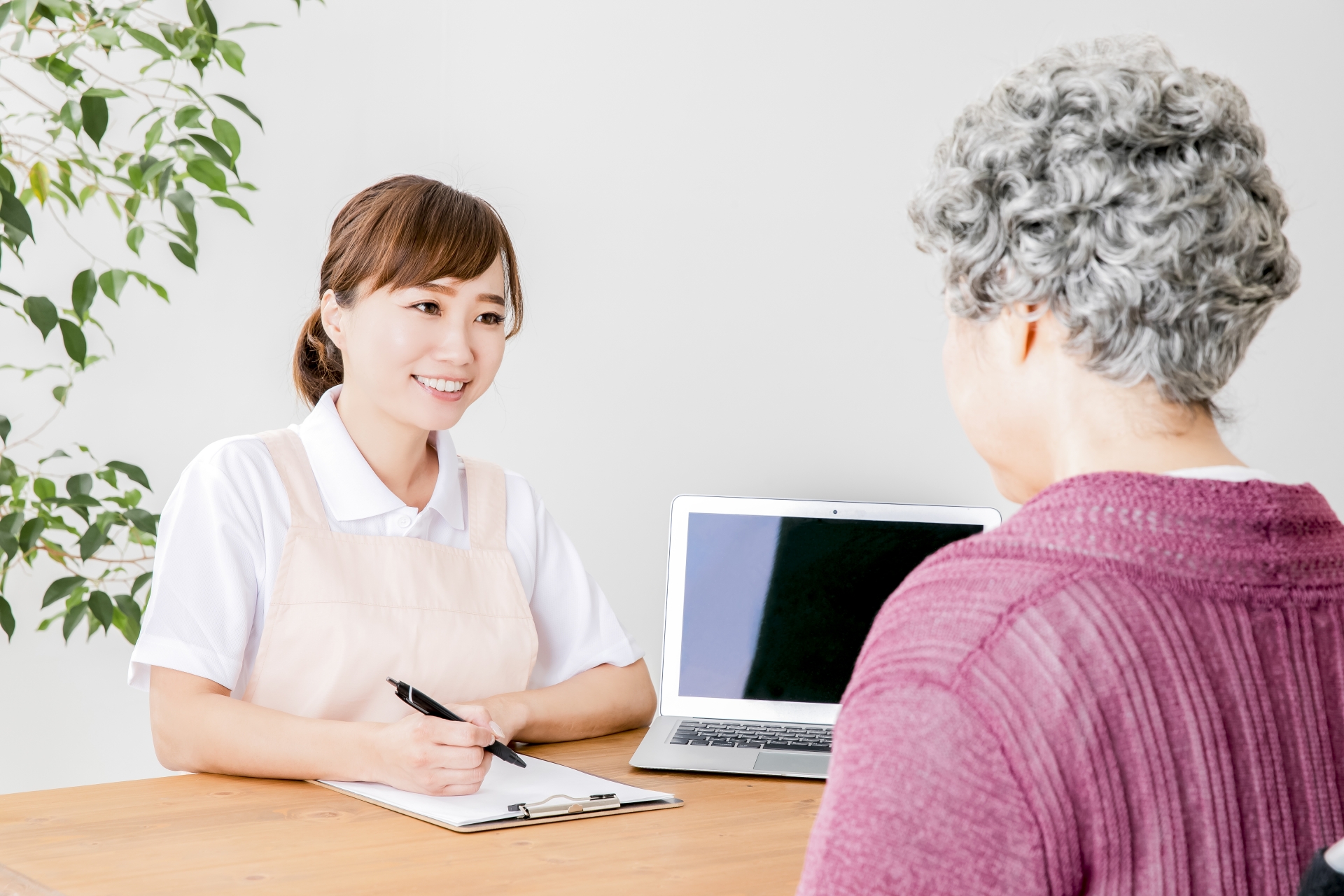 説明する介護士と高齢者の女性