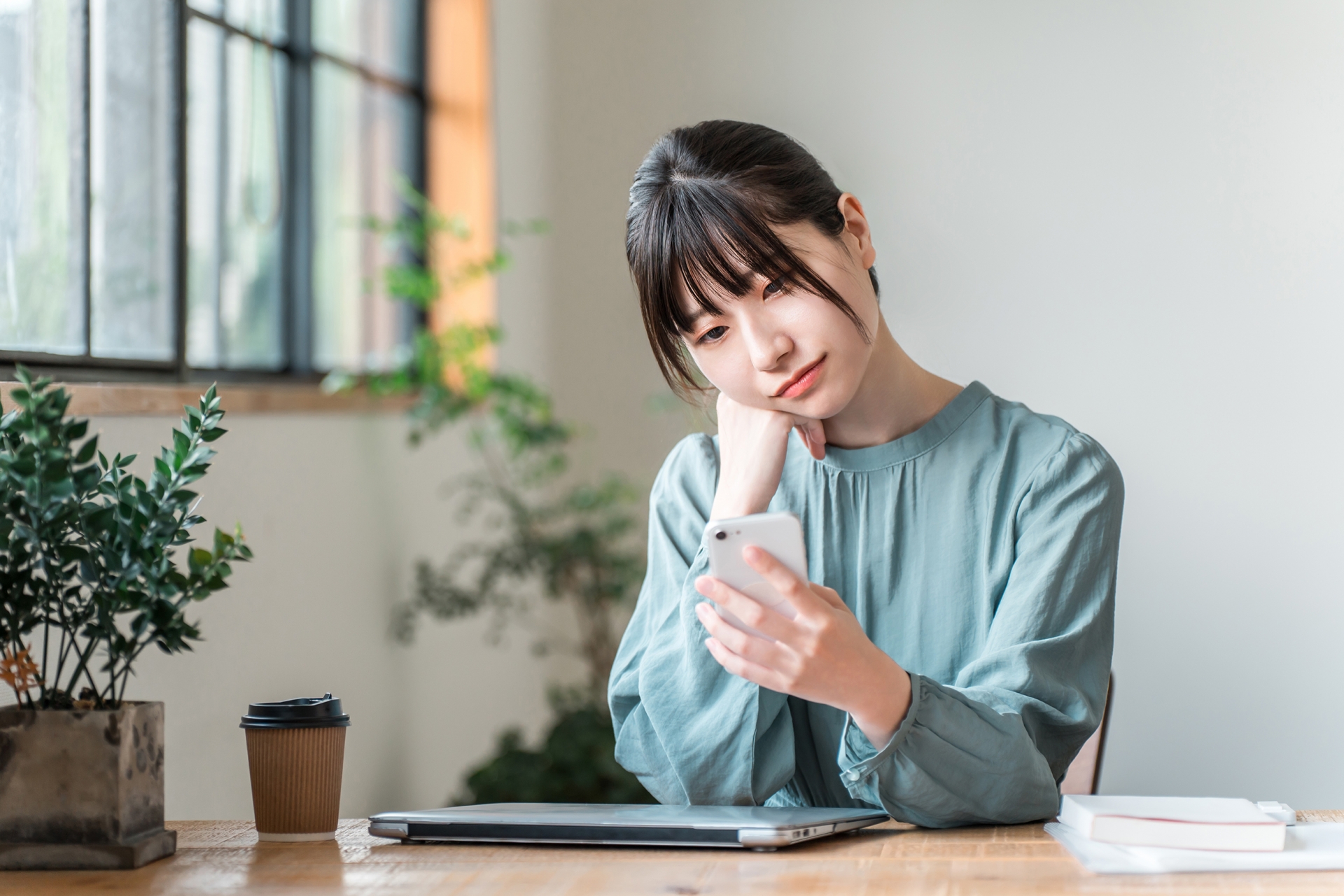 カフェでスマホを使う若いビジネスウーマン