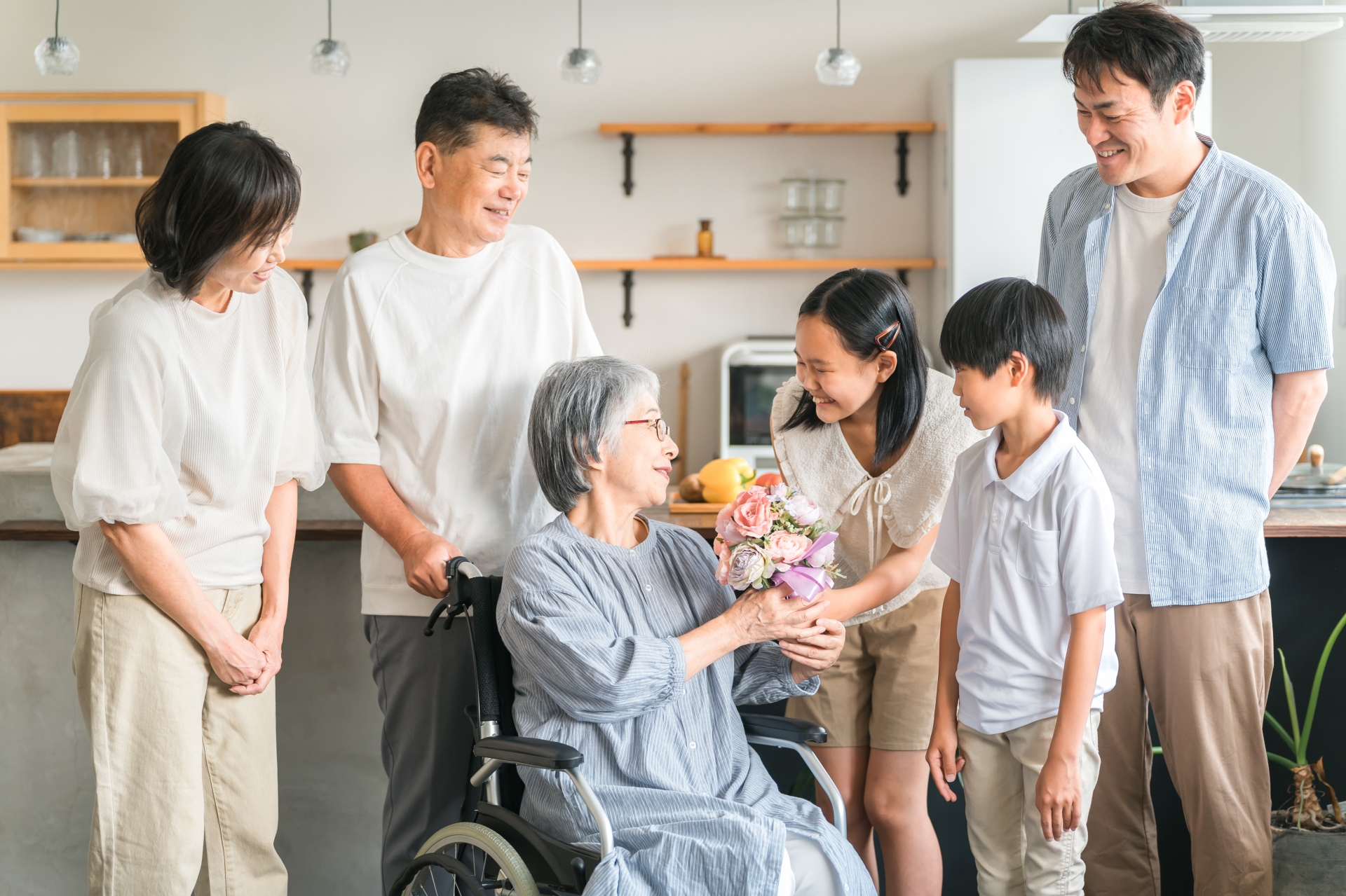 車椅子の女性と家族