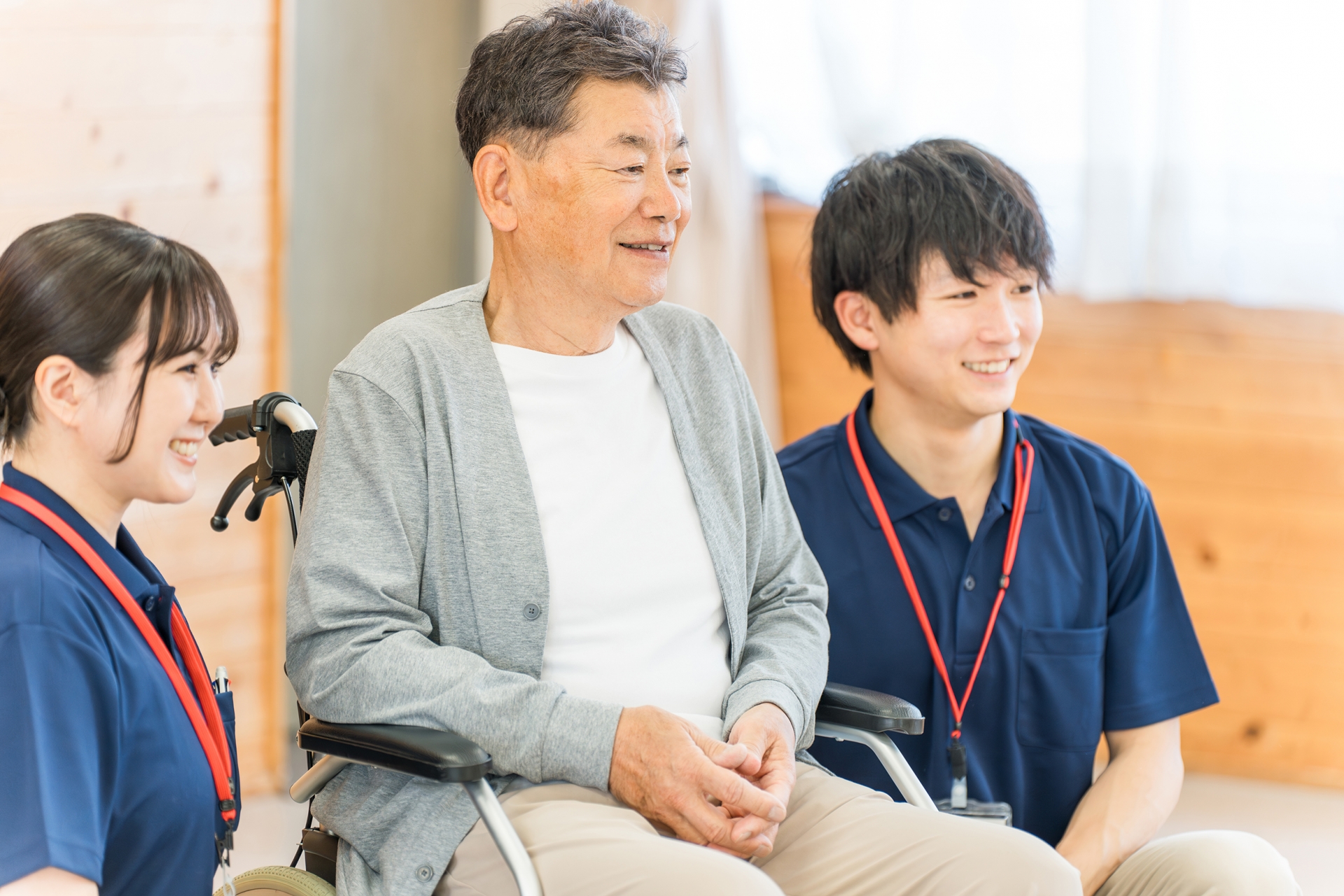 介護施設にいるシニア男性と介護職員の男女