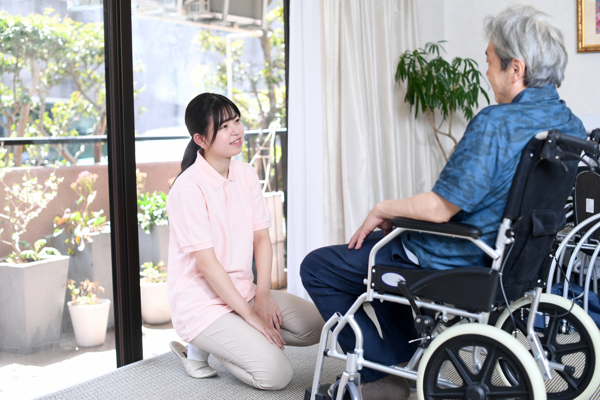 車椅子に乗る高齢者と女性の介護士