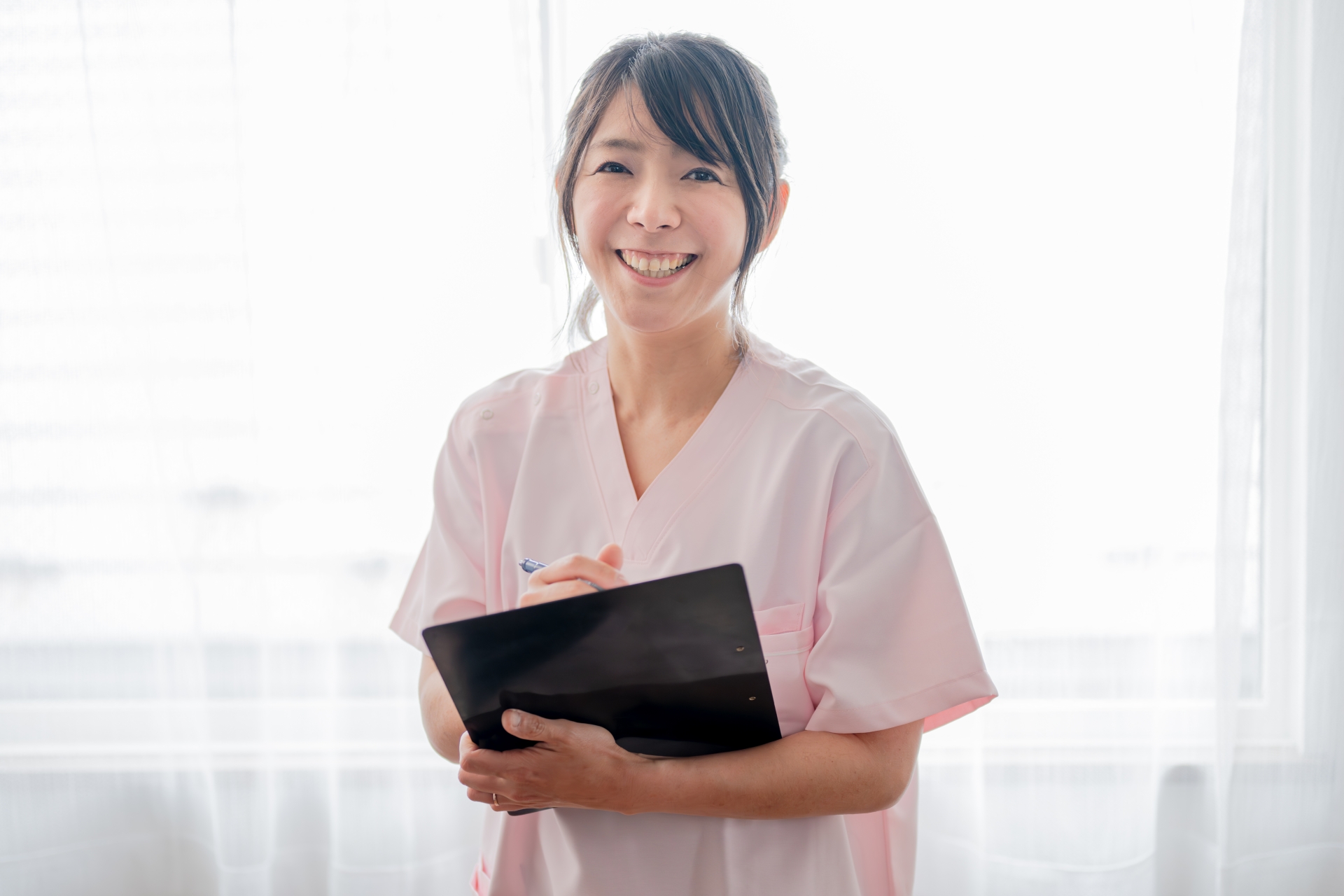 バインダーを手にする笑顔の介護職員