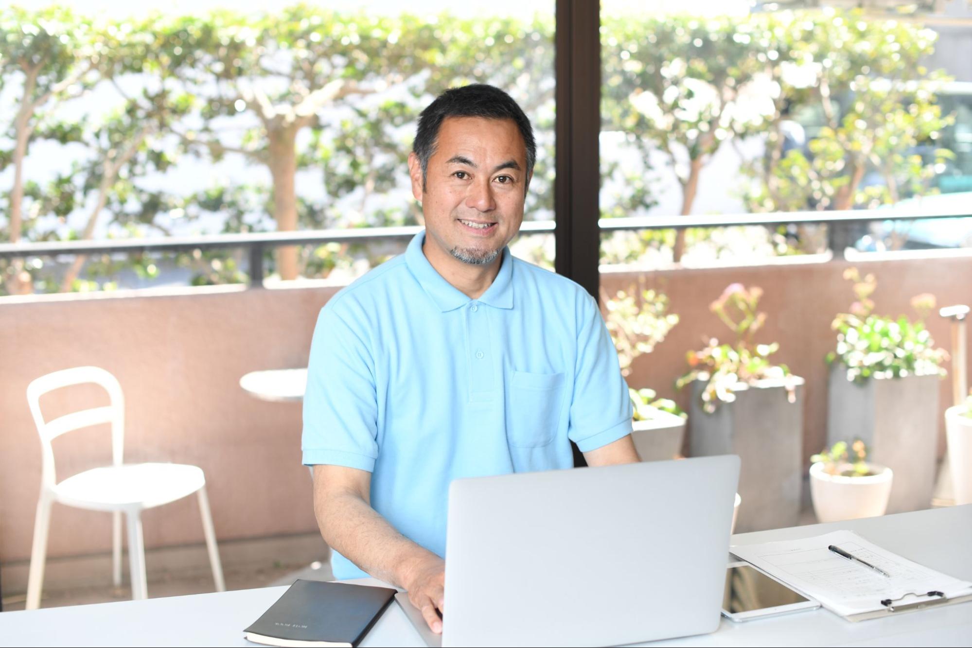 PCで事務作業をする笑顔のアジア人男性