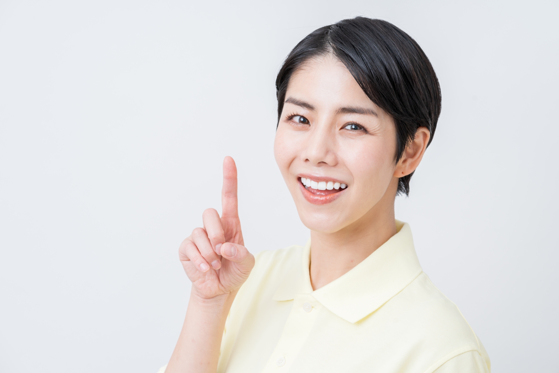 人差し指を立てる笑顔の女性