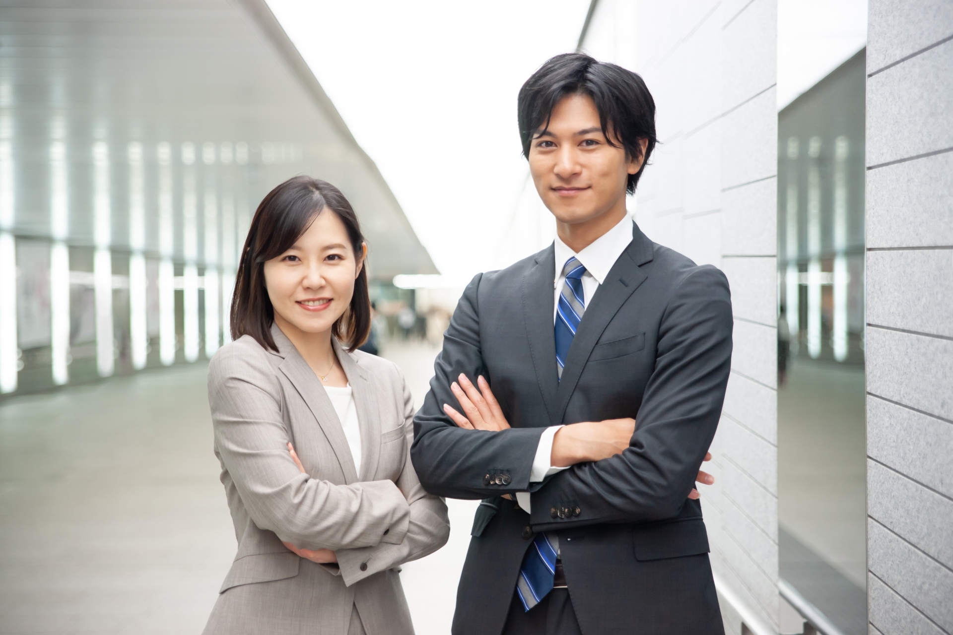 腕組するスーツの男女