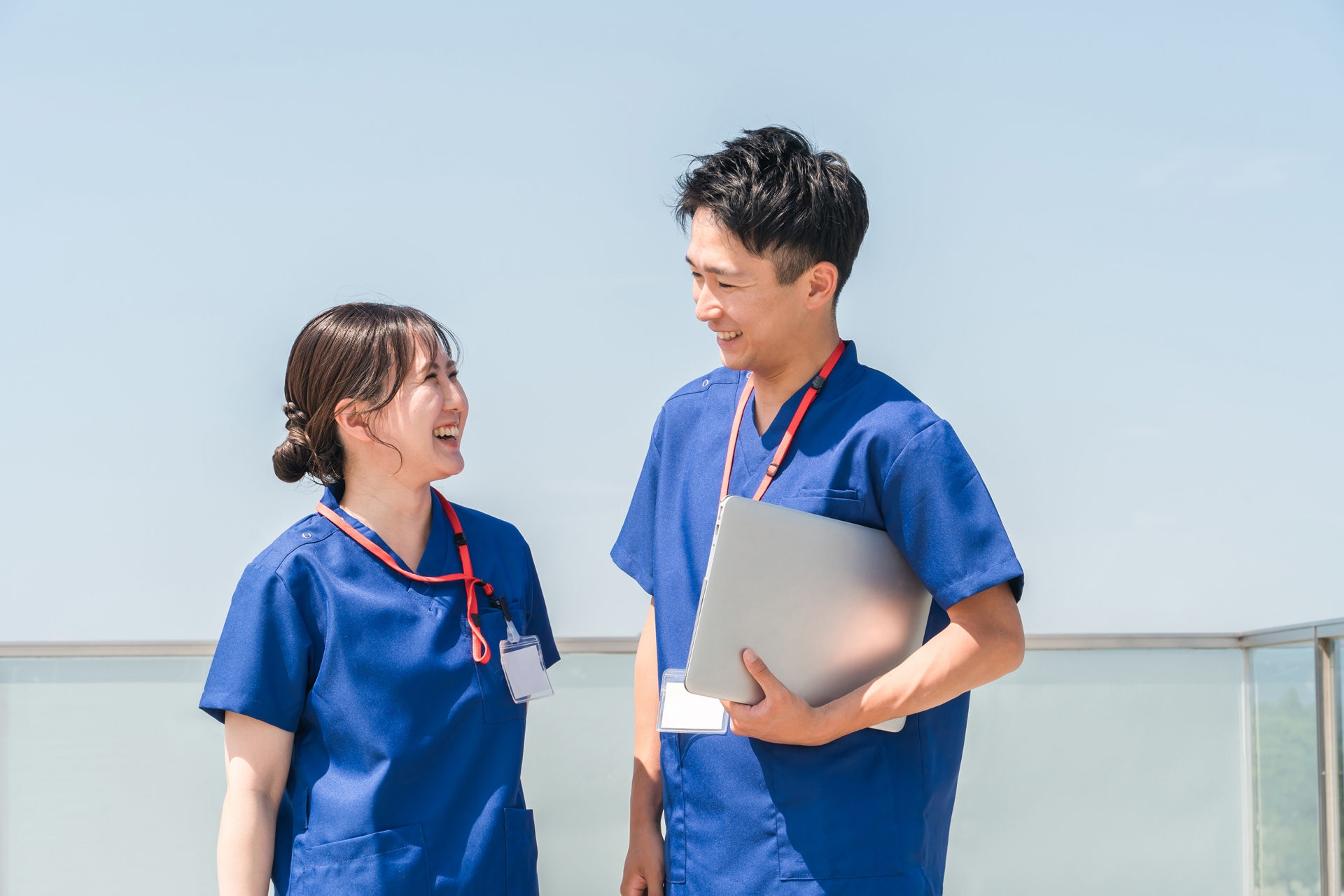 屋上で話をする看護師の男女