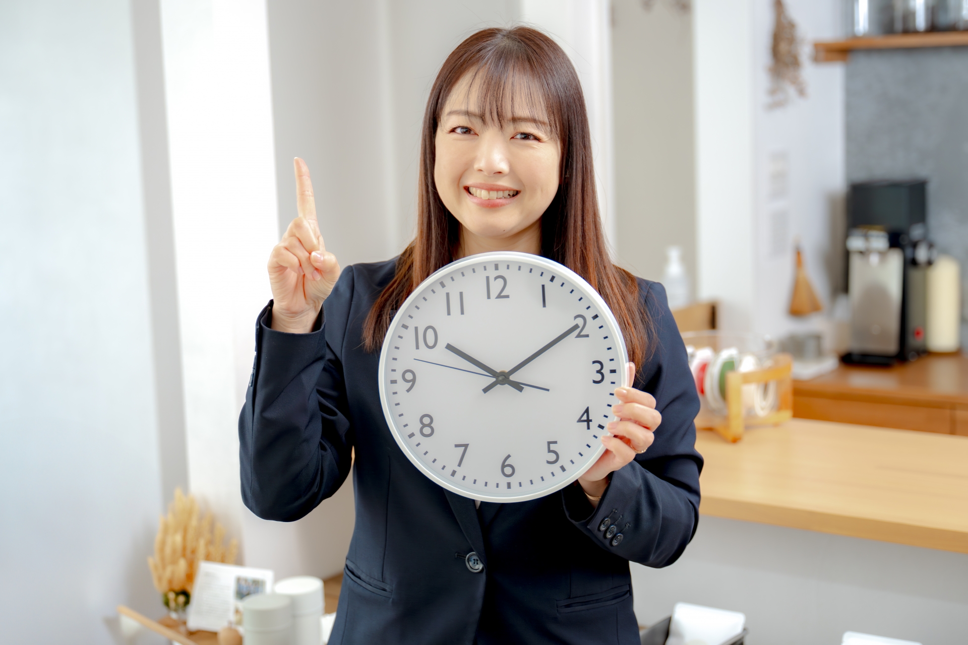 時計を持って指を立てる女性
