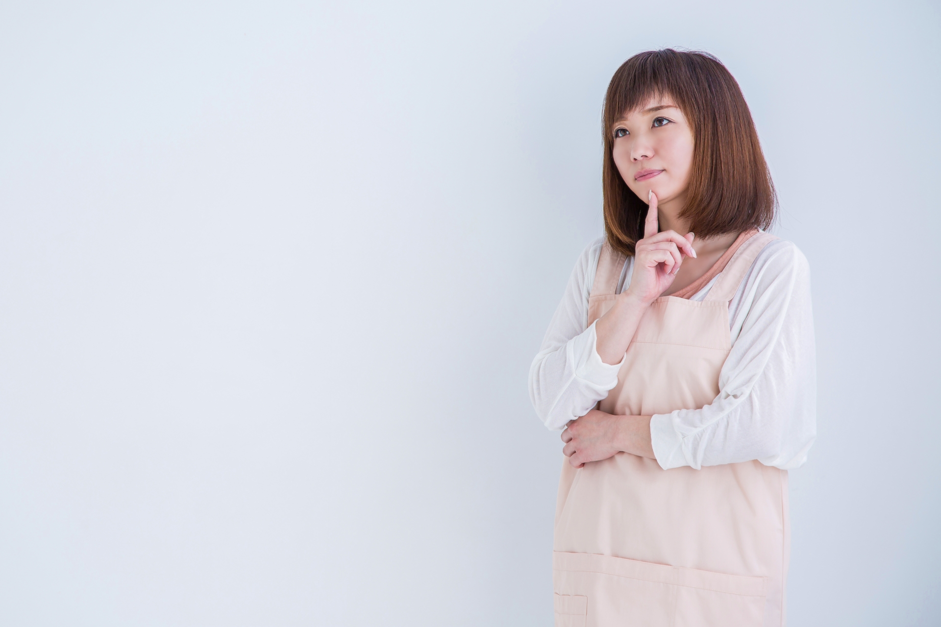 顎に指を当てて悩む女性