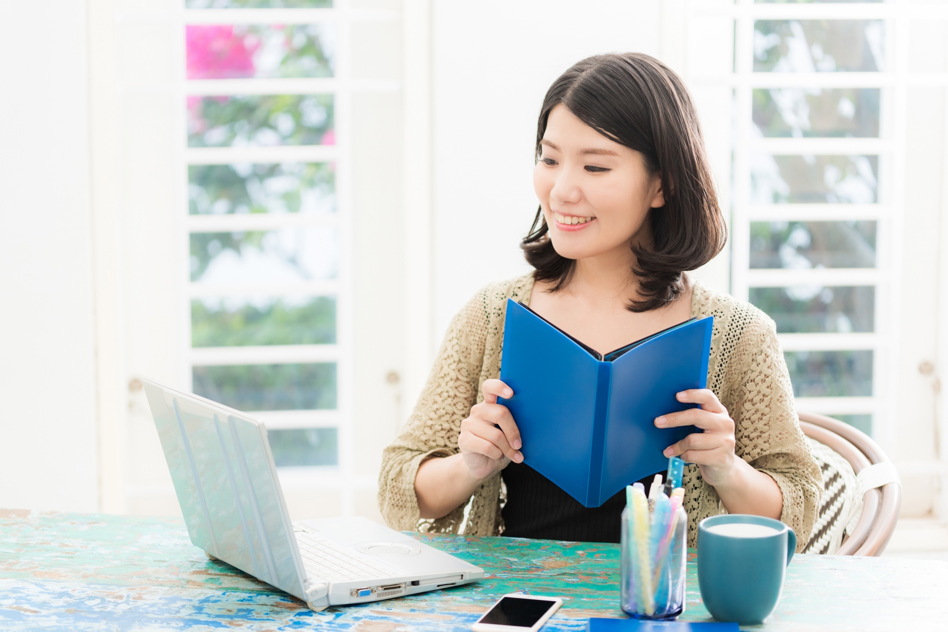 PCやノートを開く女性