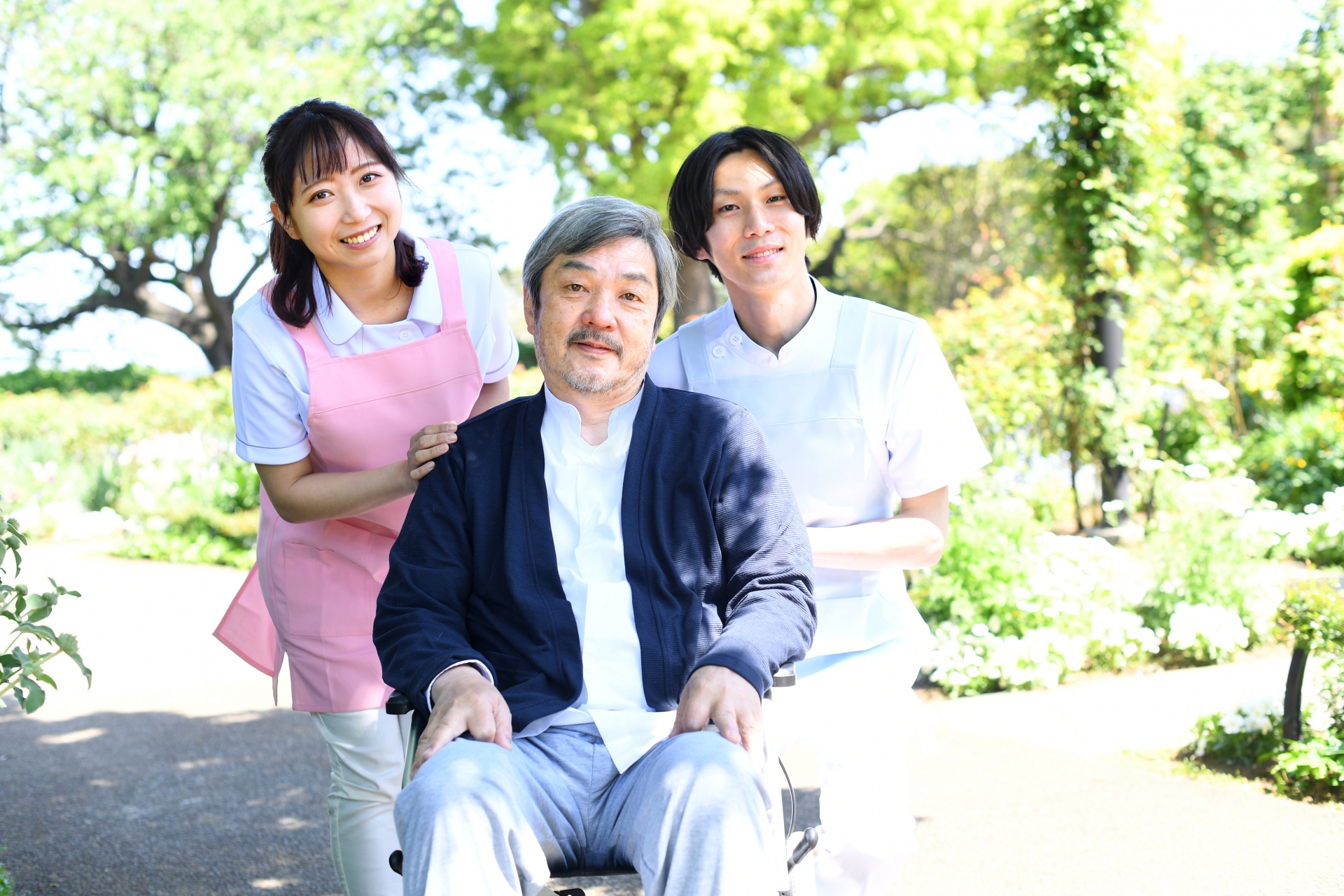 介護ヘルパーの男女と車椅子のシニア男性