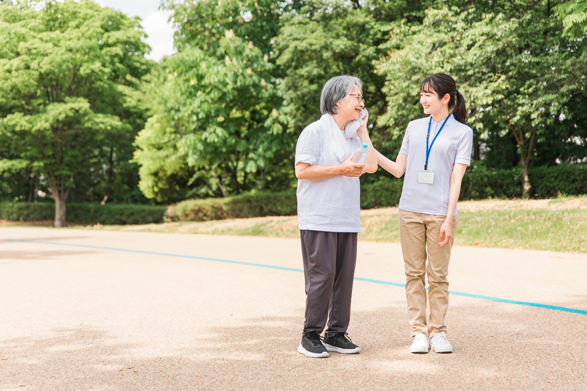 外で汗を拭く高齢女性