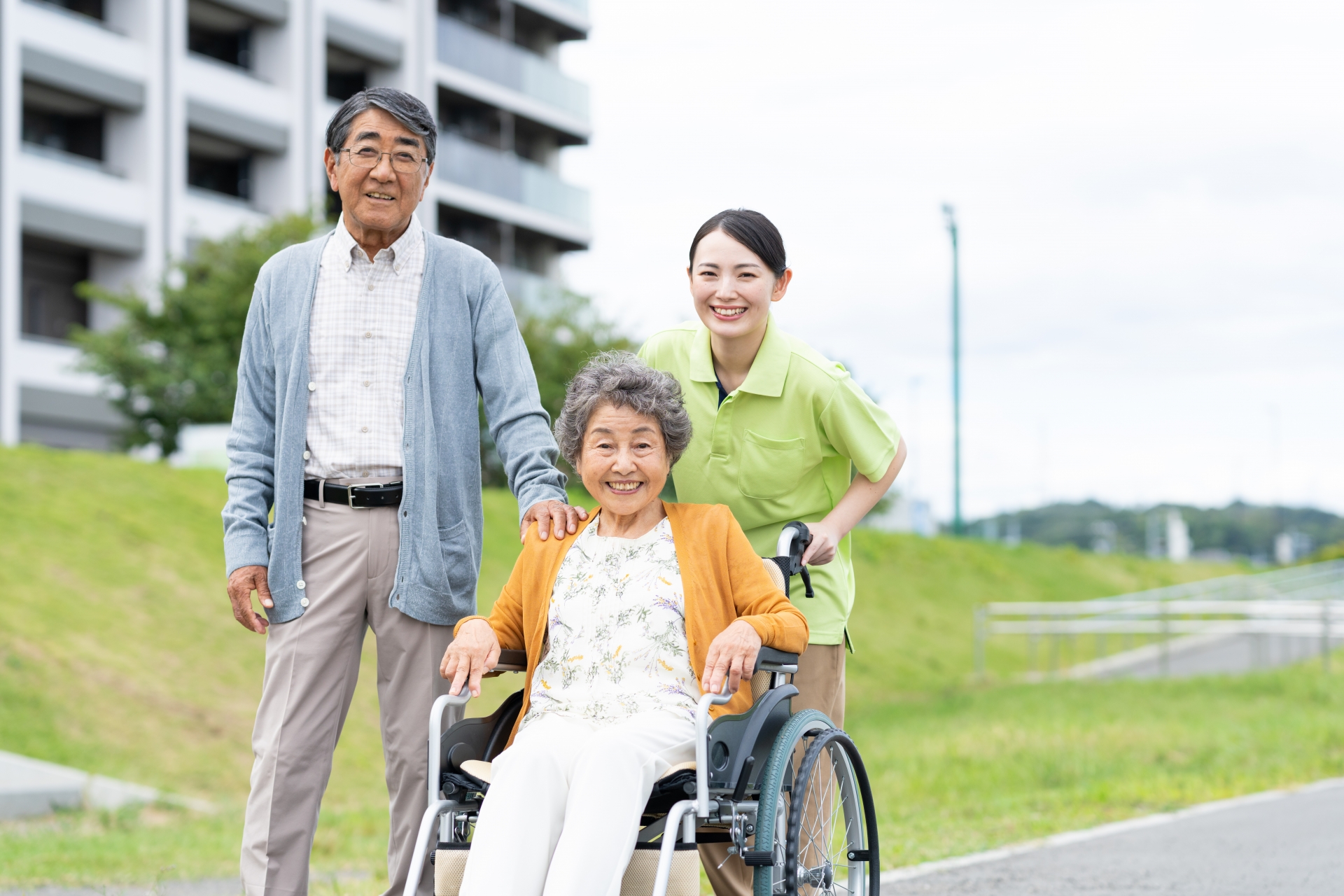 車椅子のシニアの夫婦と介護福祉士