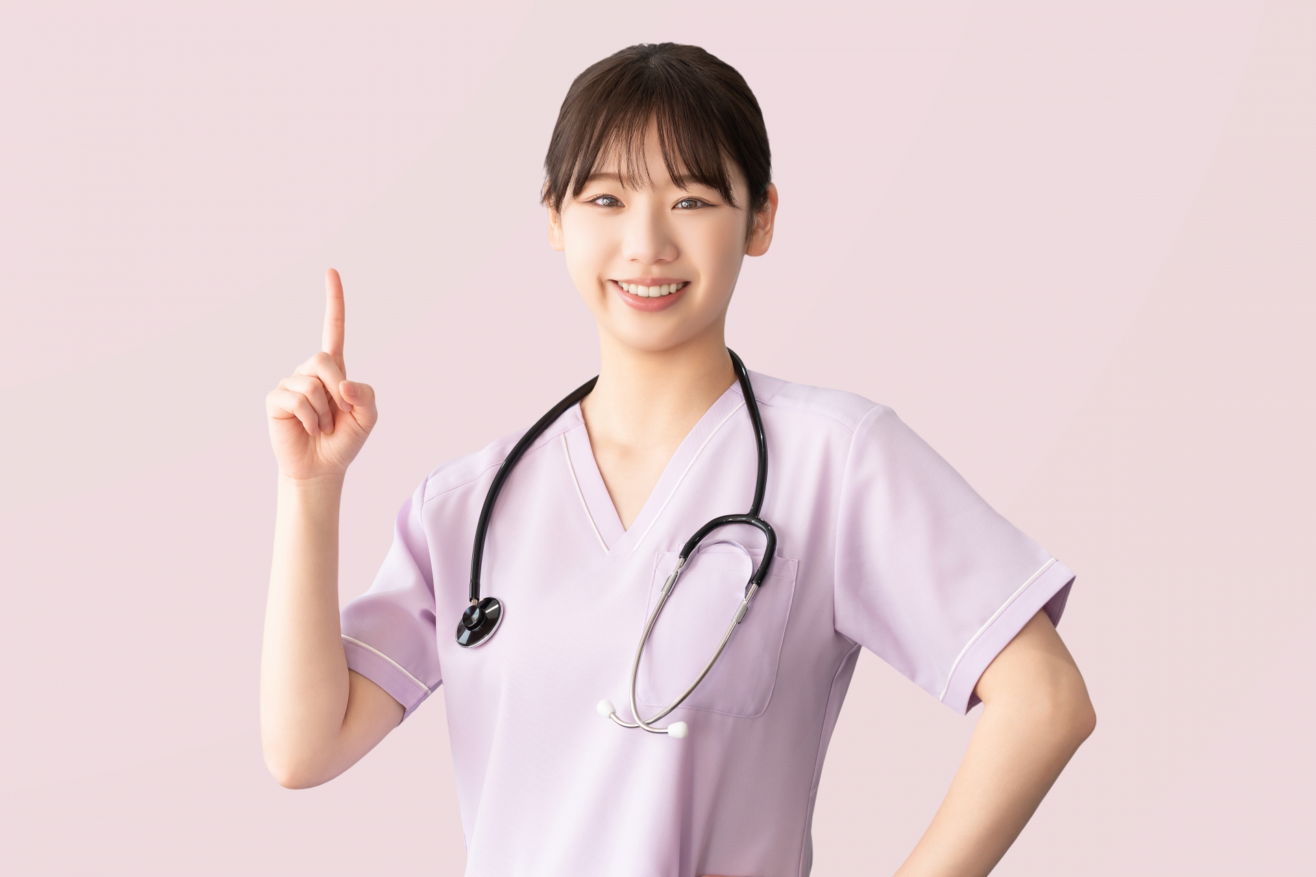 人差し指を立てて案内する女性医療スタッフ