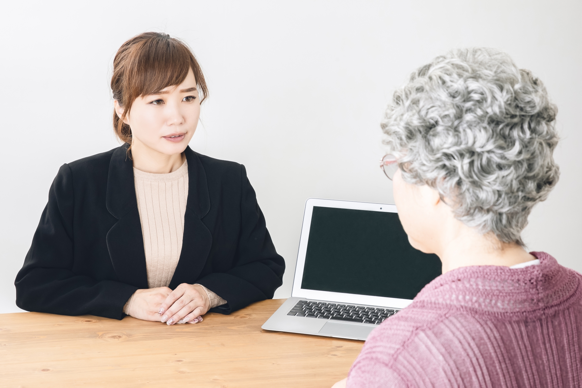 慰めるスーツ姿の女性と高齢者