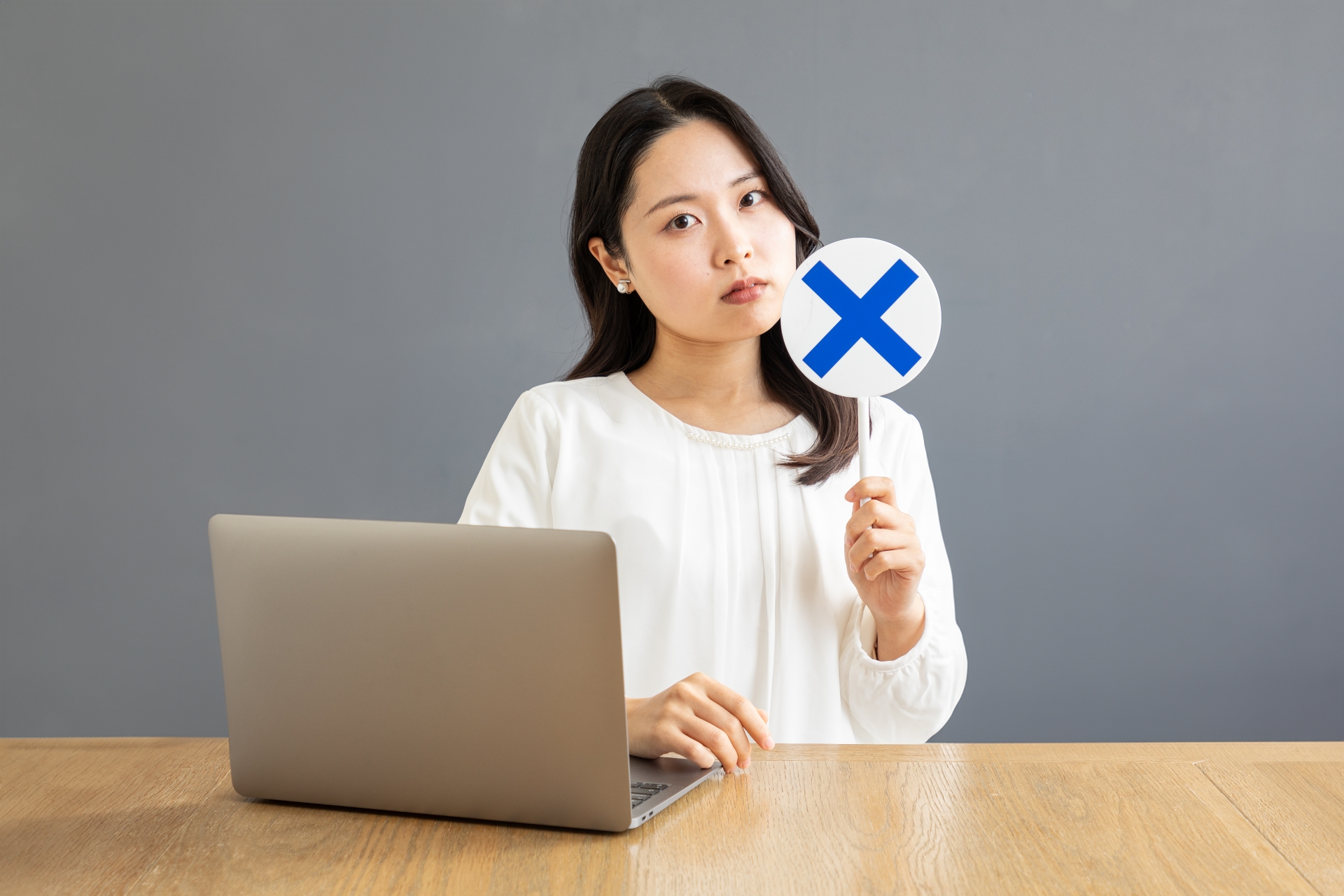 バツ印を出すPC前の女性