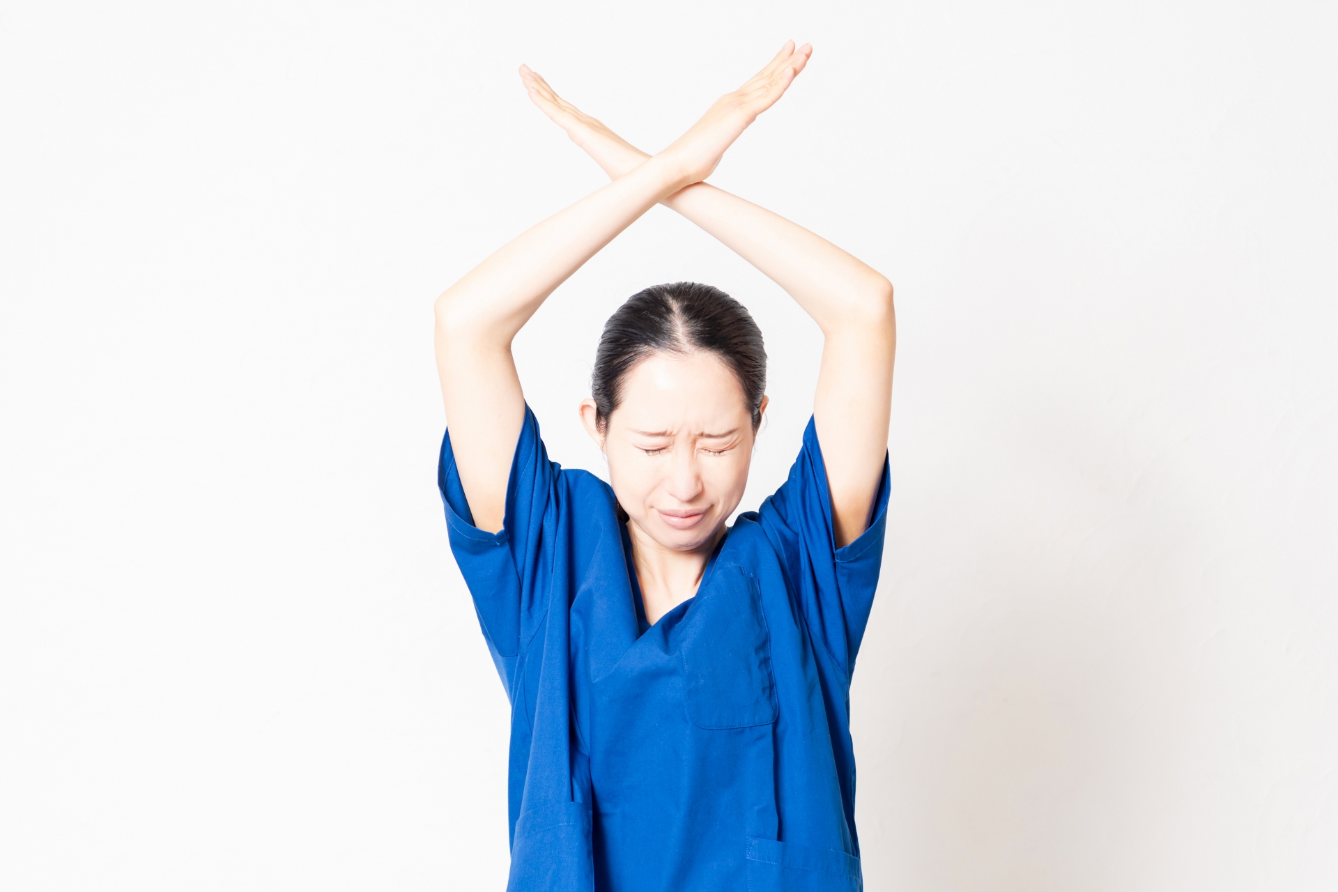 手でバツを作る女性介護士