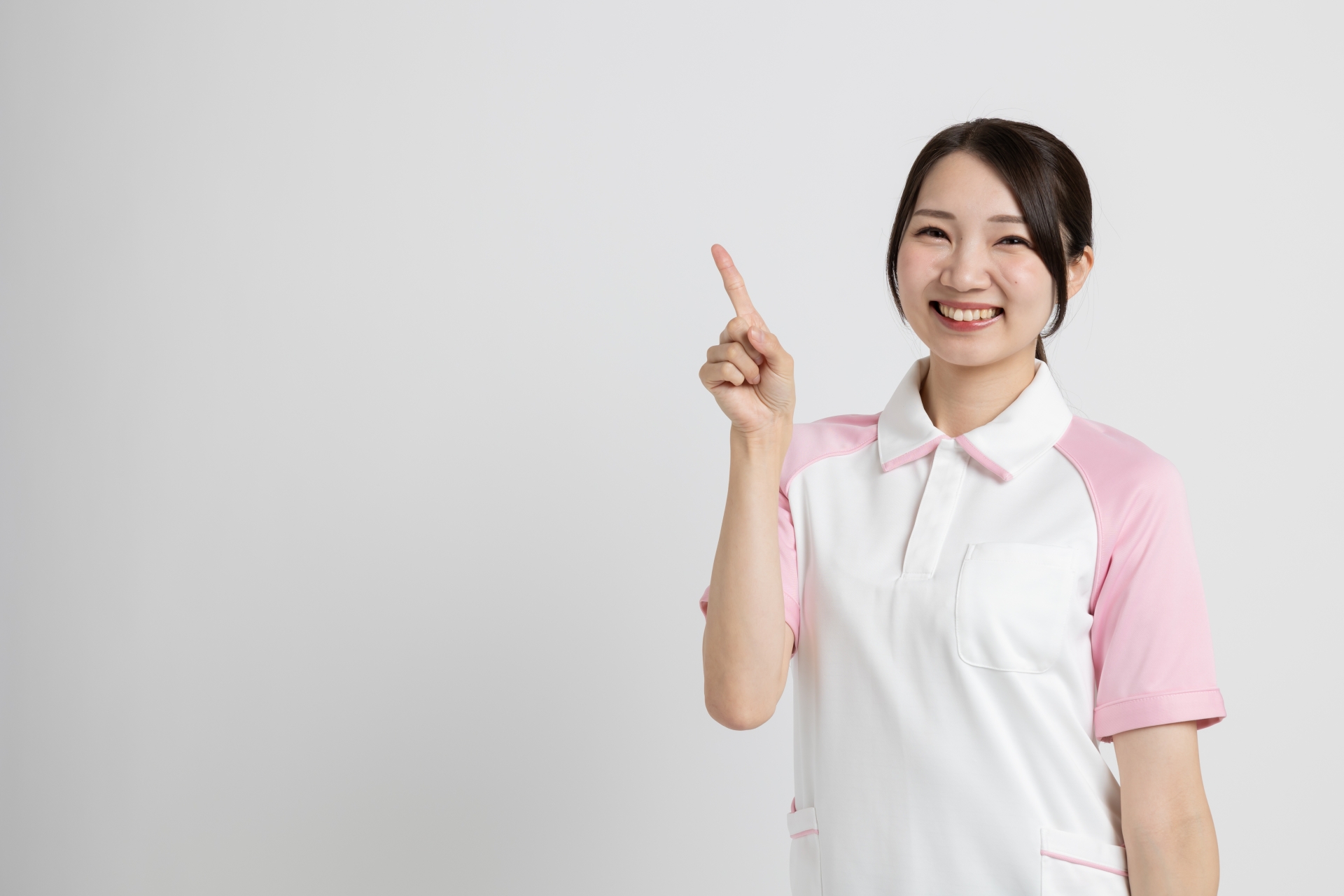 人差し指を立てる女性介護士