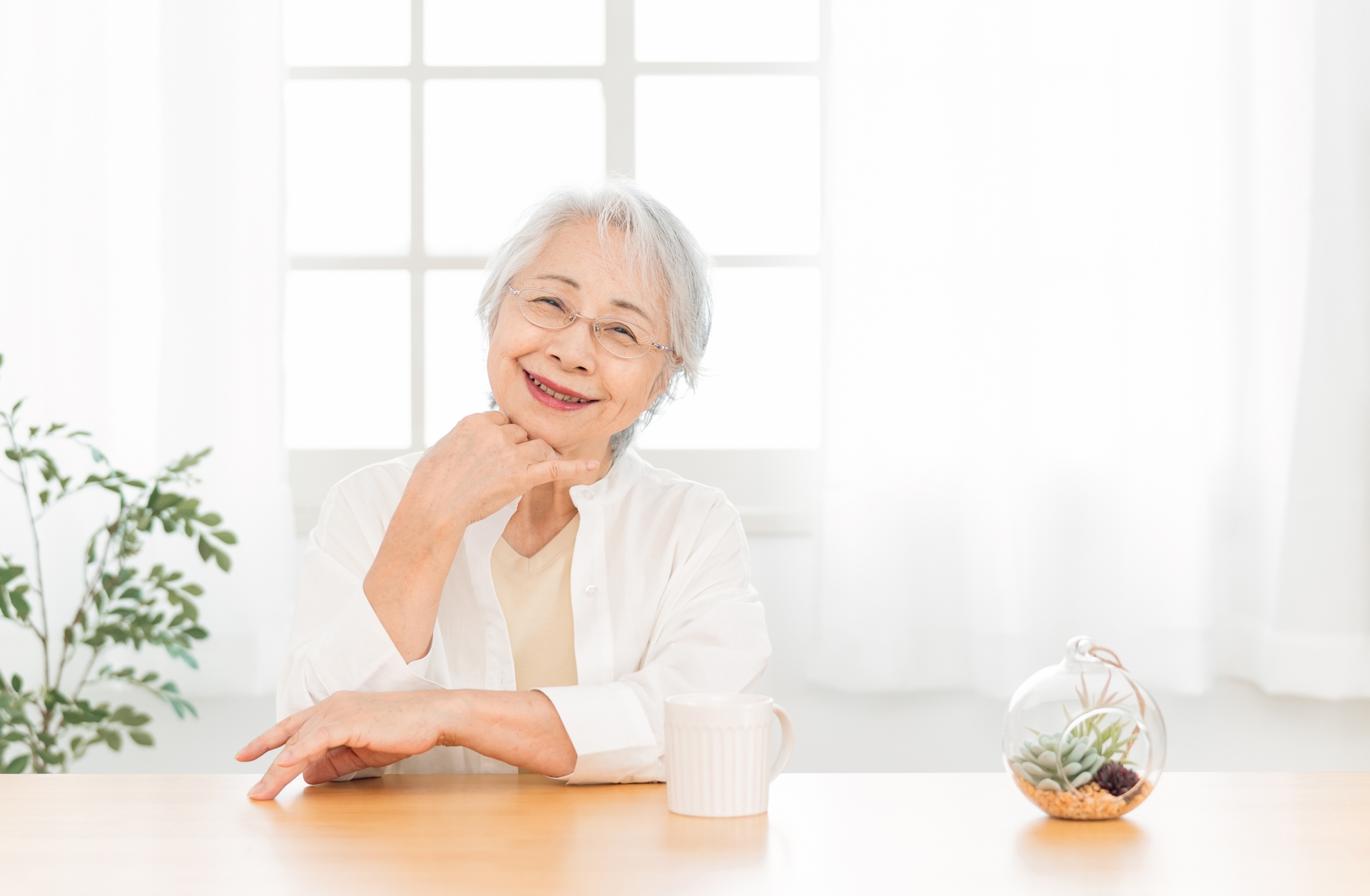 窓辺に座る高齢者女性
