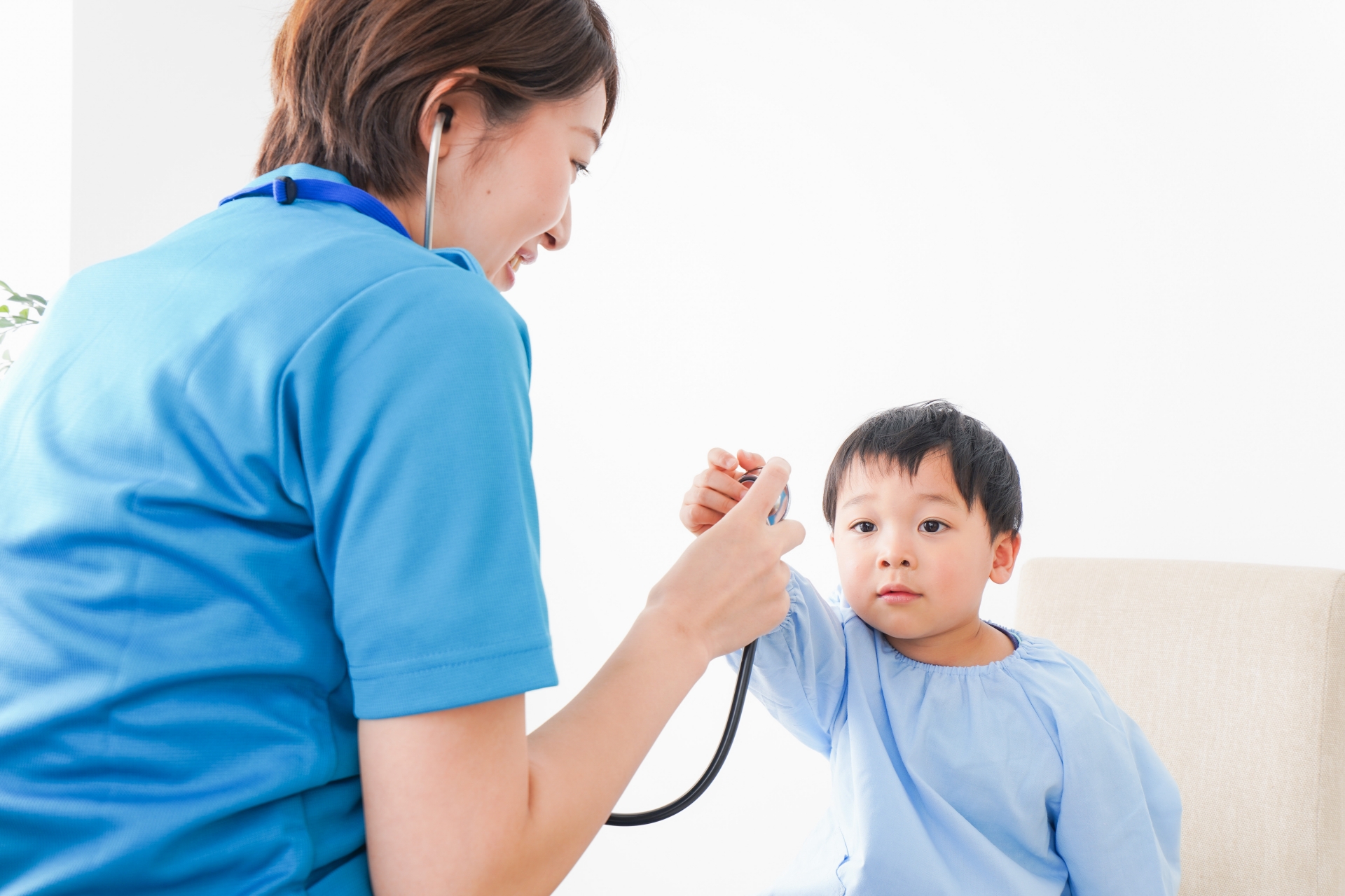 子どもを診察する若い看護師