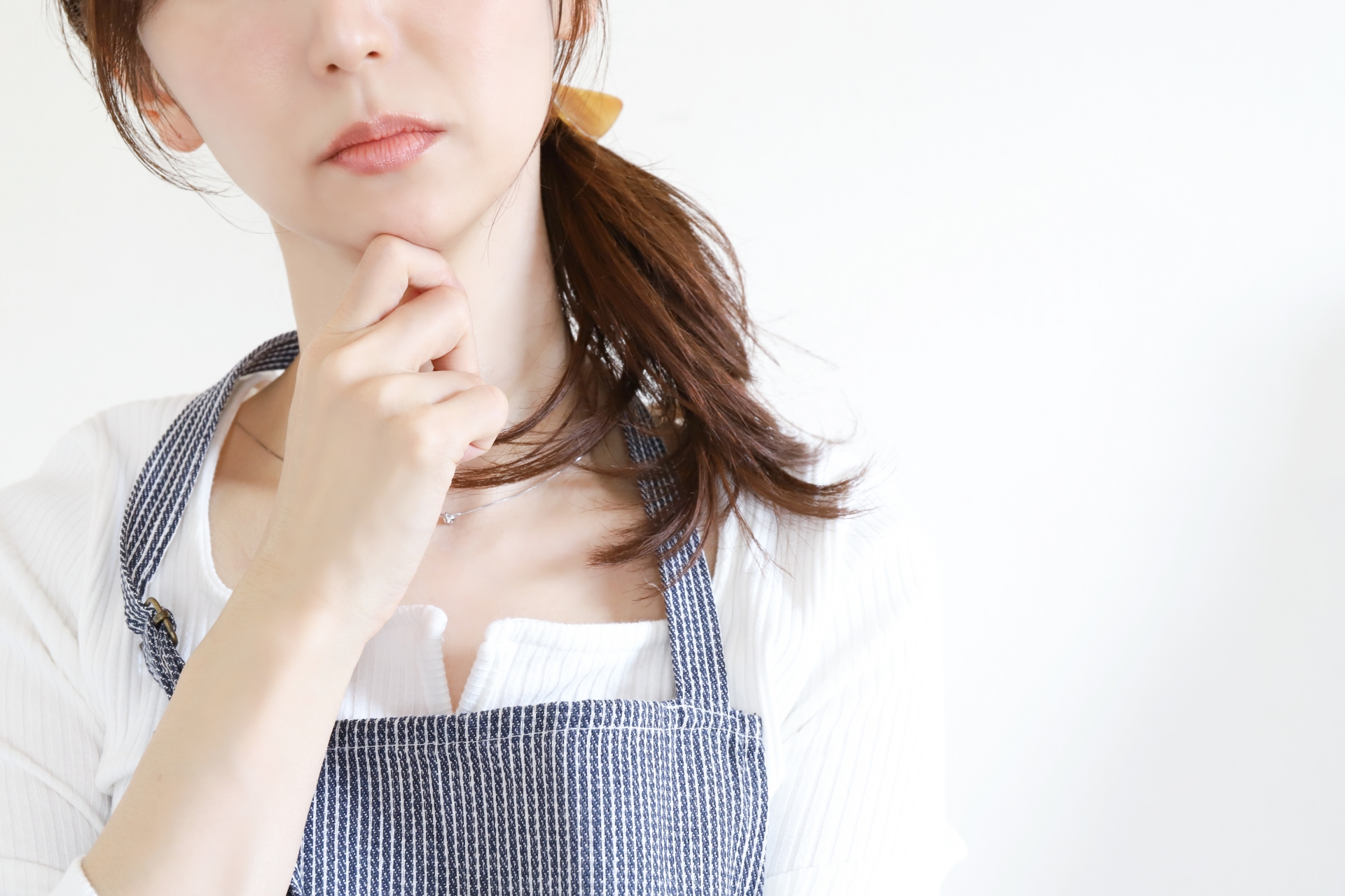 考えるエプロンの女性