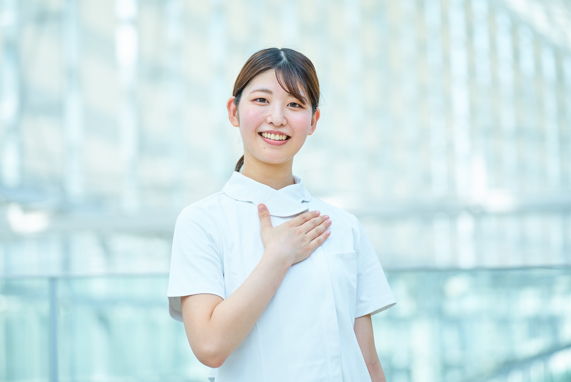 胸に手を当てる白衣の女性