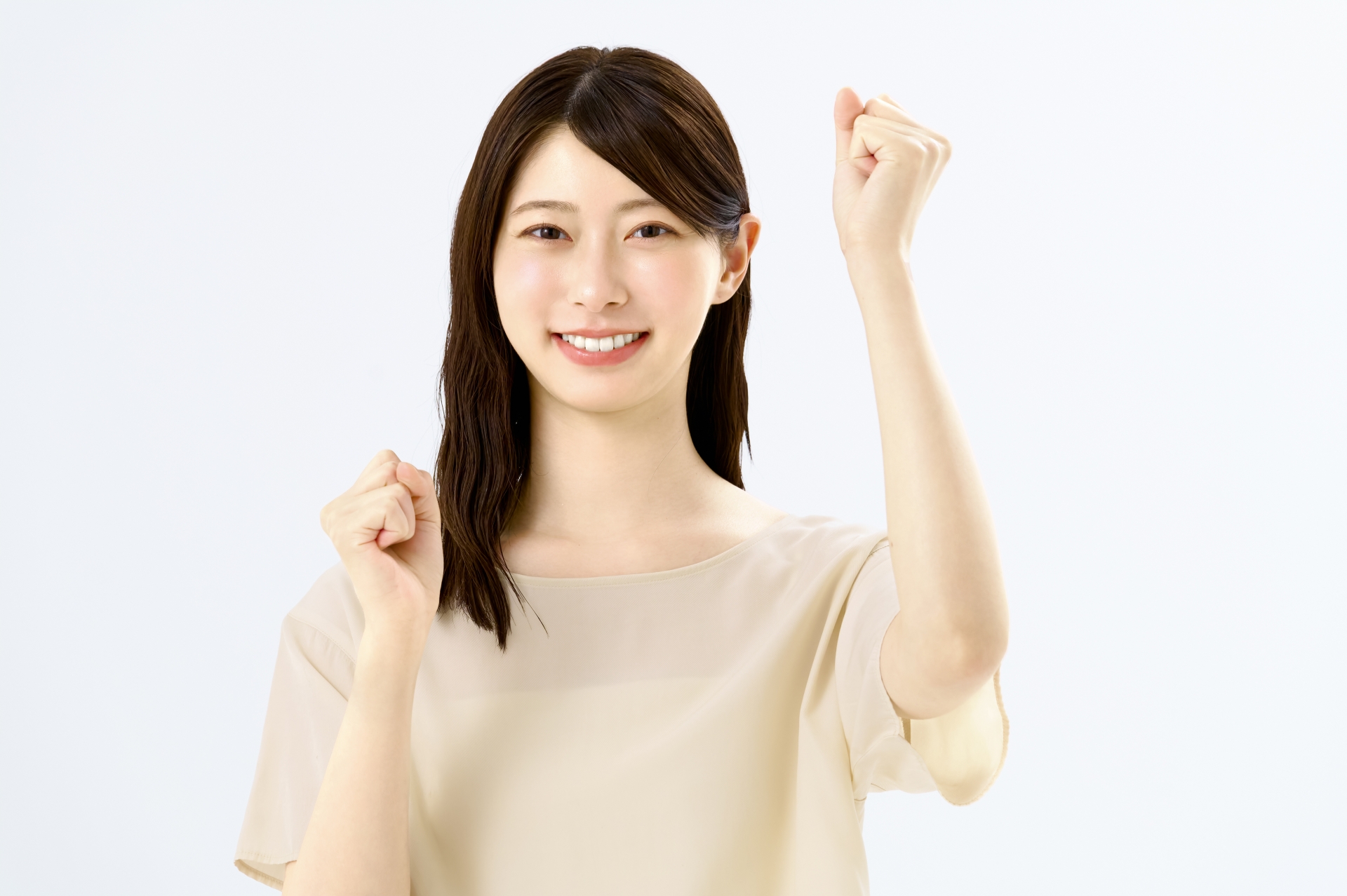 両手でガッツポーズをする笑顔の若い女性