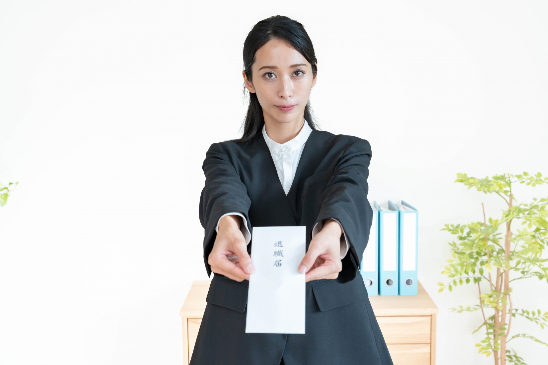 辞表を持つスーツを着た女性