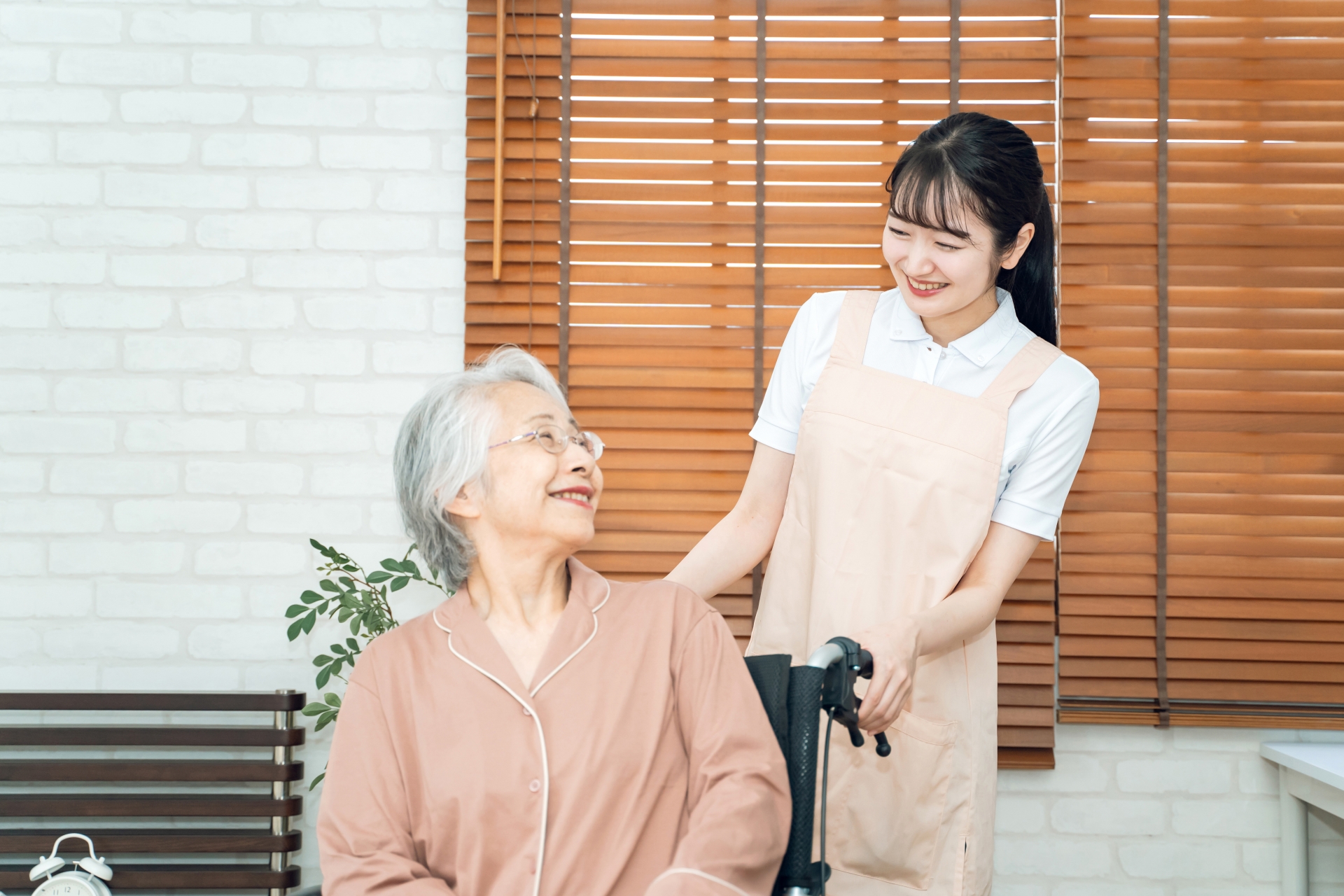 笑顔で向き合う高齢女性とヘルパー