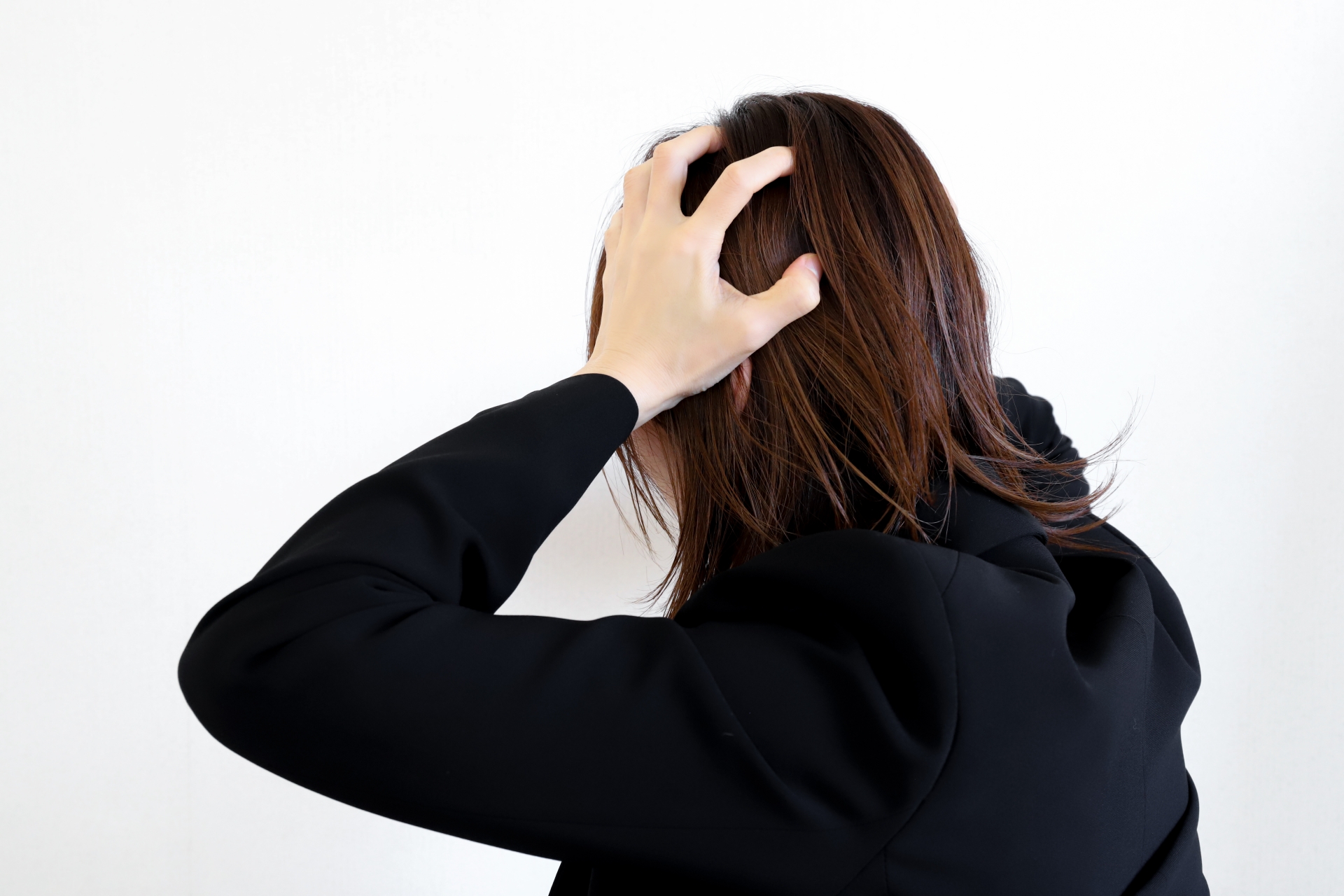 頭を抱えるスーツの女性
