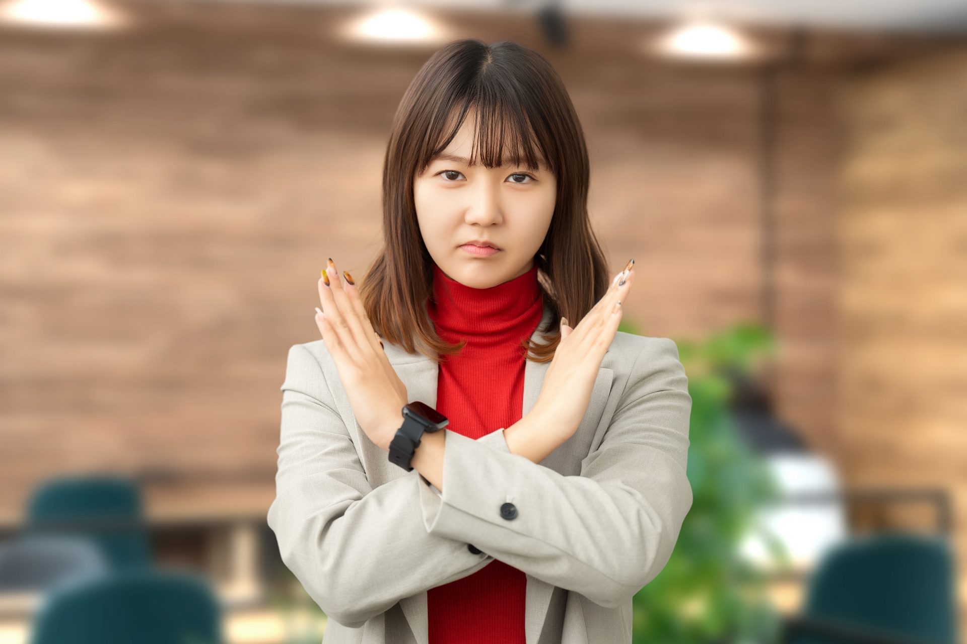 手でバツを作る女性