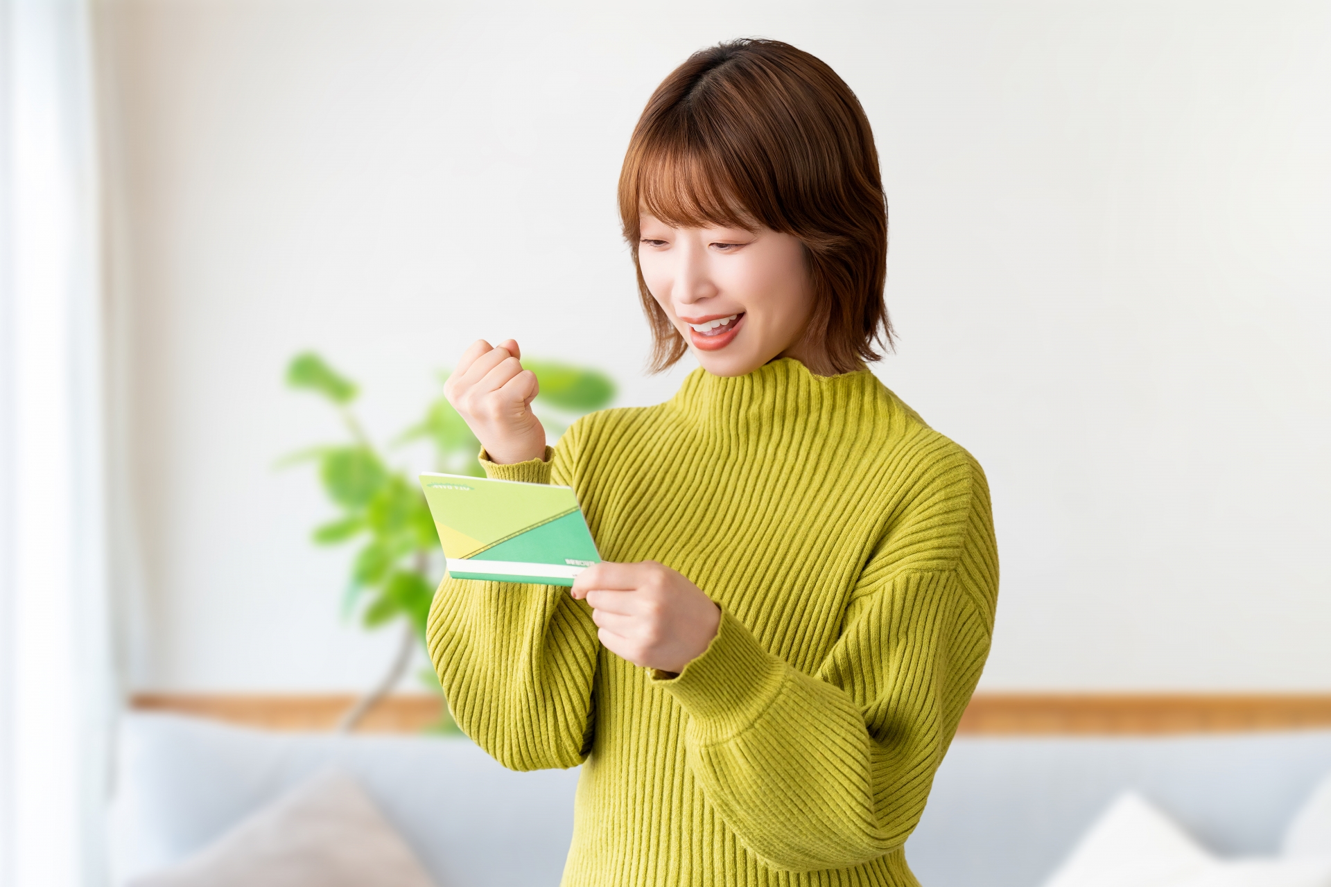 通帳を見てガッツポーズの女性