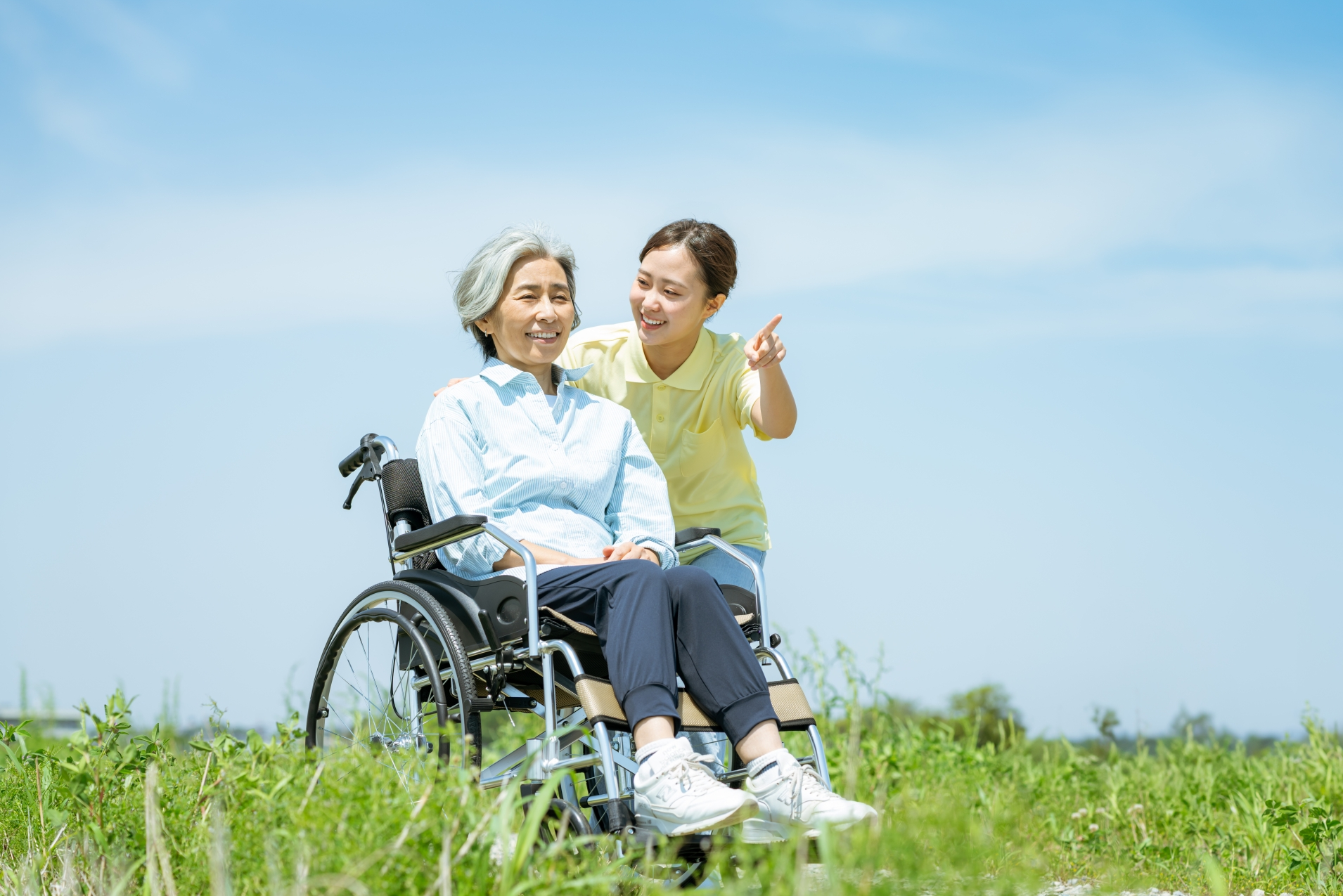 散歩をする介護士と高齢者