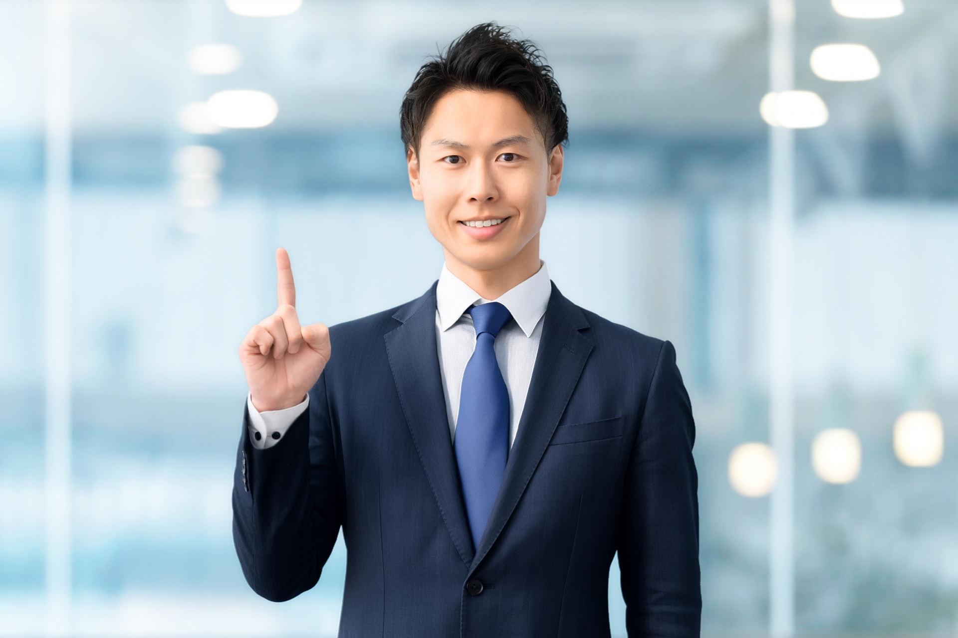 指を立てるスーツの若い男性
