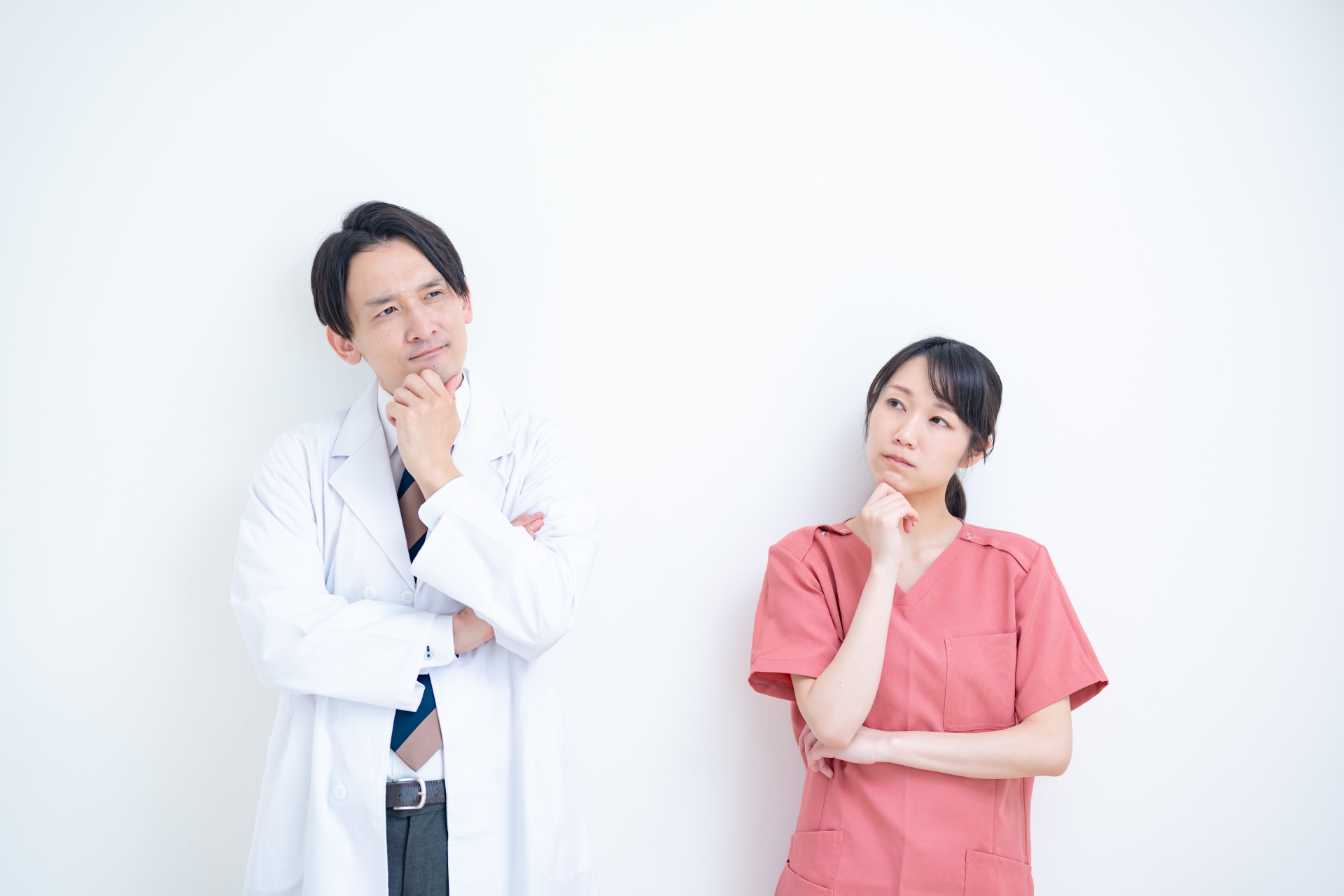 白衣を着た男性とスクラブを着た女性