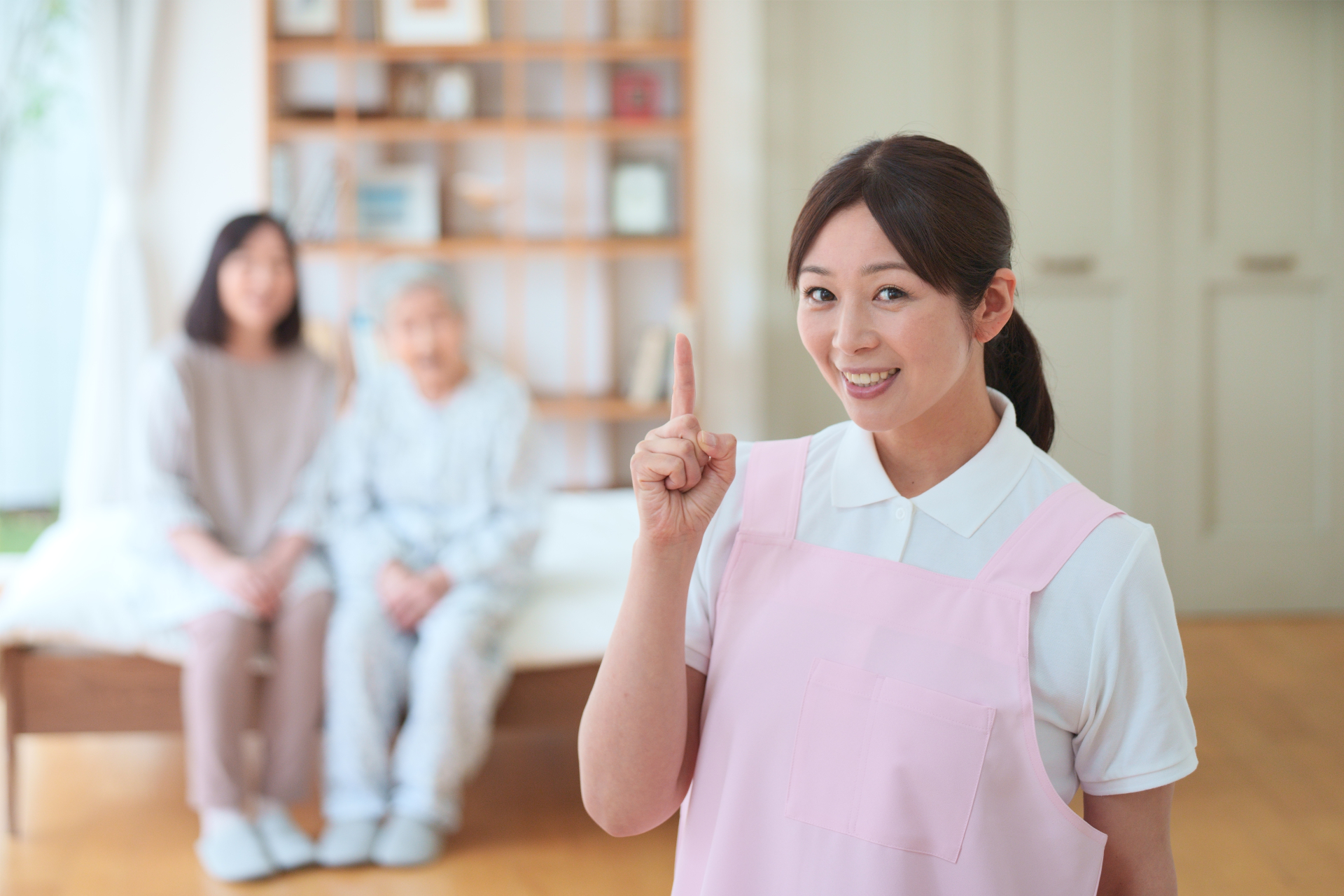 指を立てるエプロンの女性