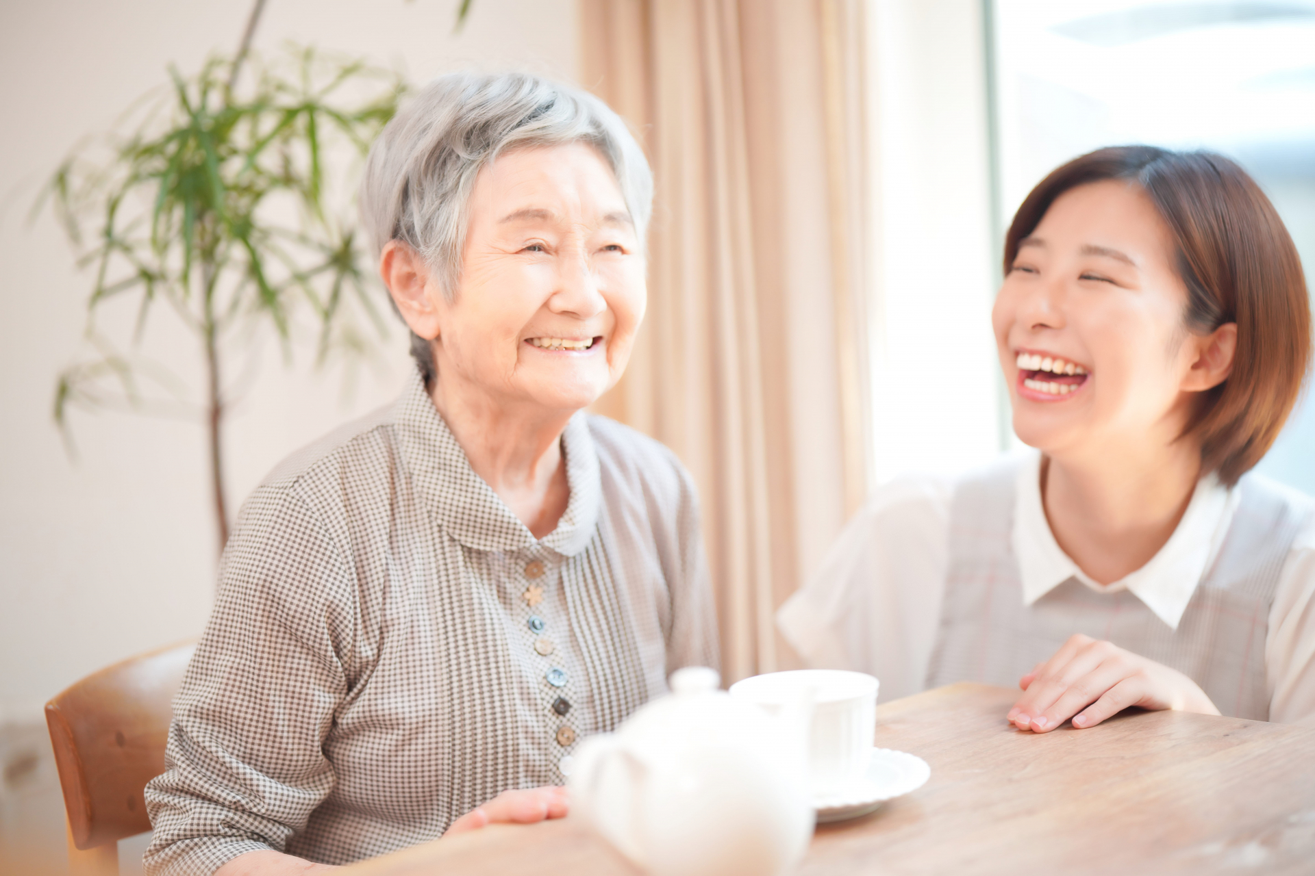 お茶をする利用者と介護士の女性