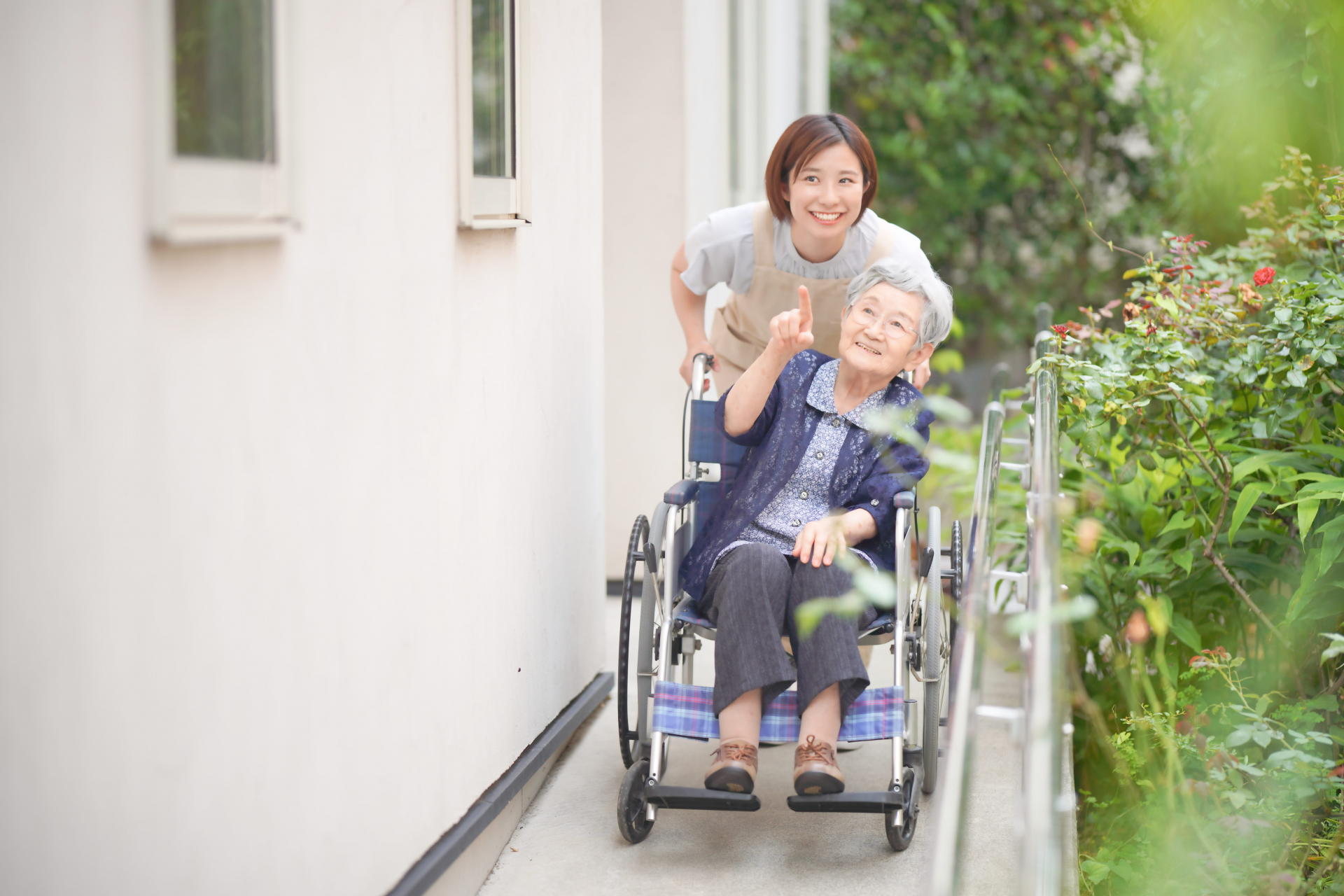 建物のそばで車椅子を押す介護士