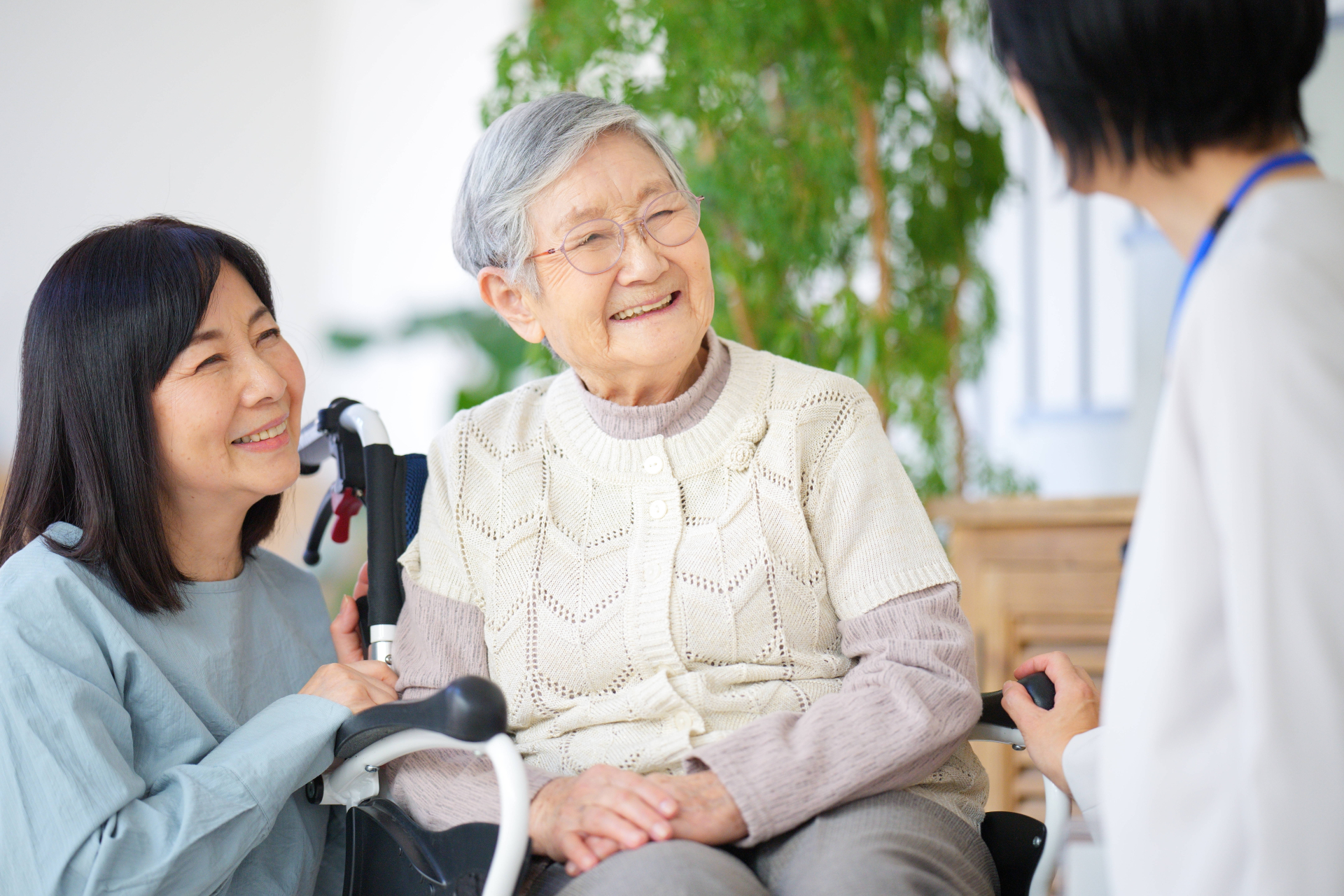 車椅子の女性と家族と介護士