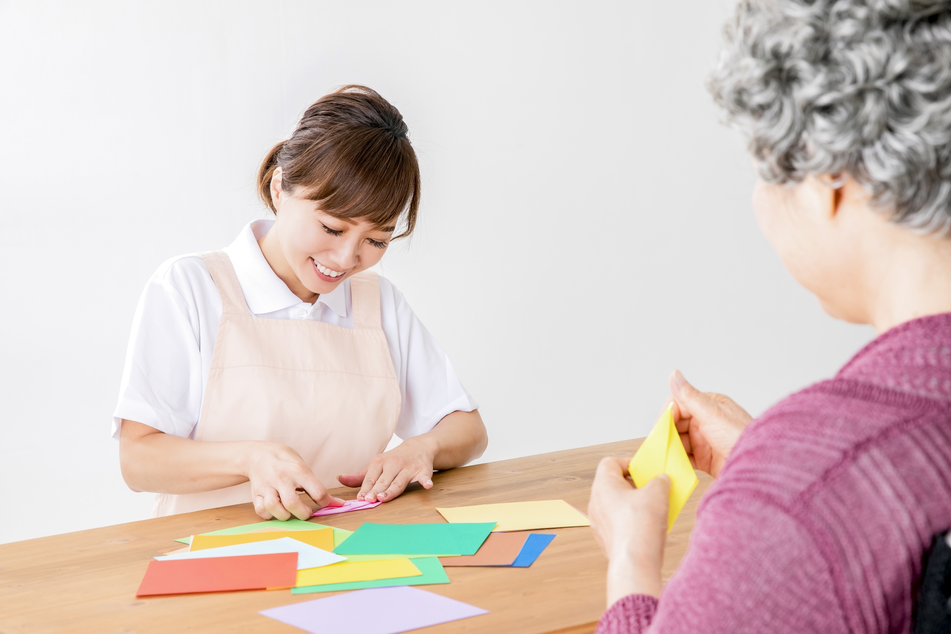 折り紙を折る利用者と介護士