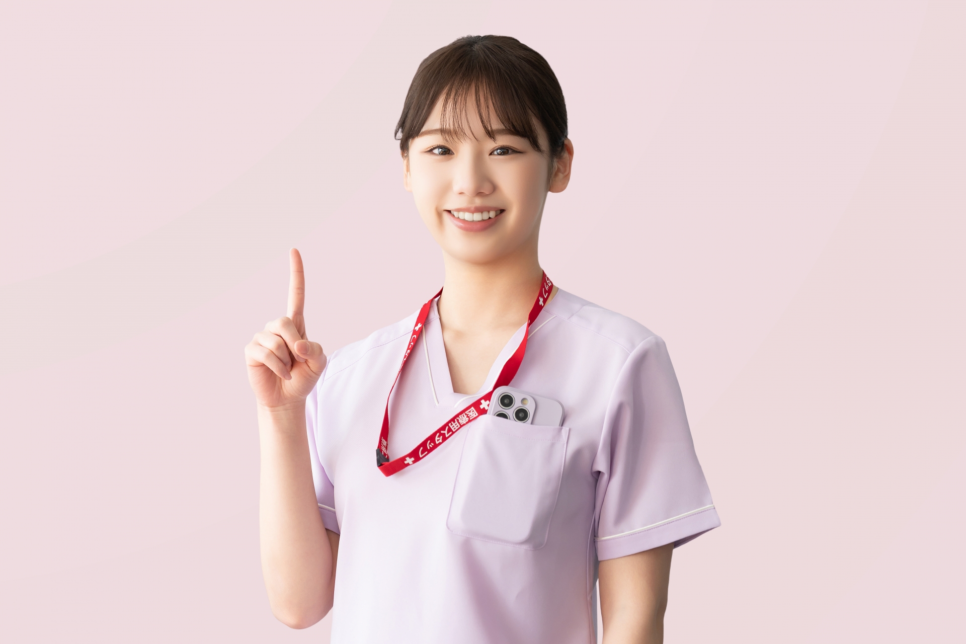 人差し指を立てて案内する女性医療スタッフ
