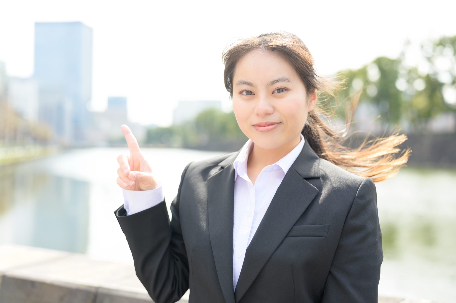 屋外で指をさす女性