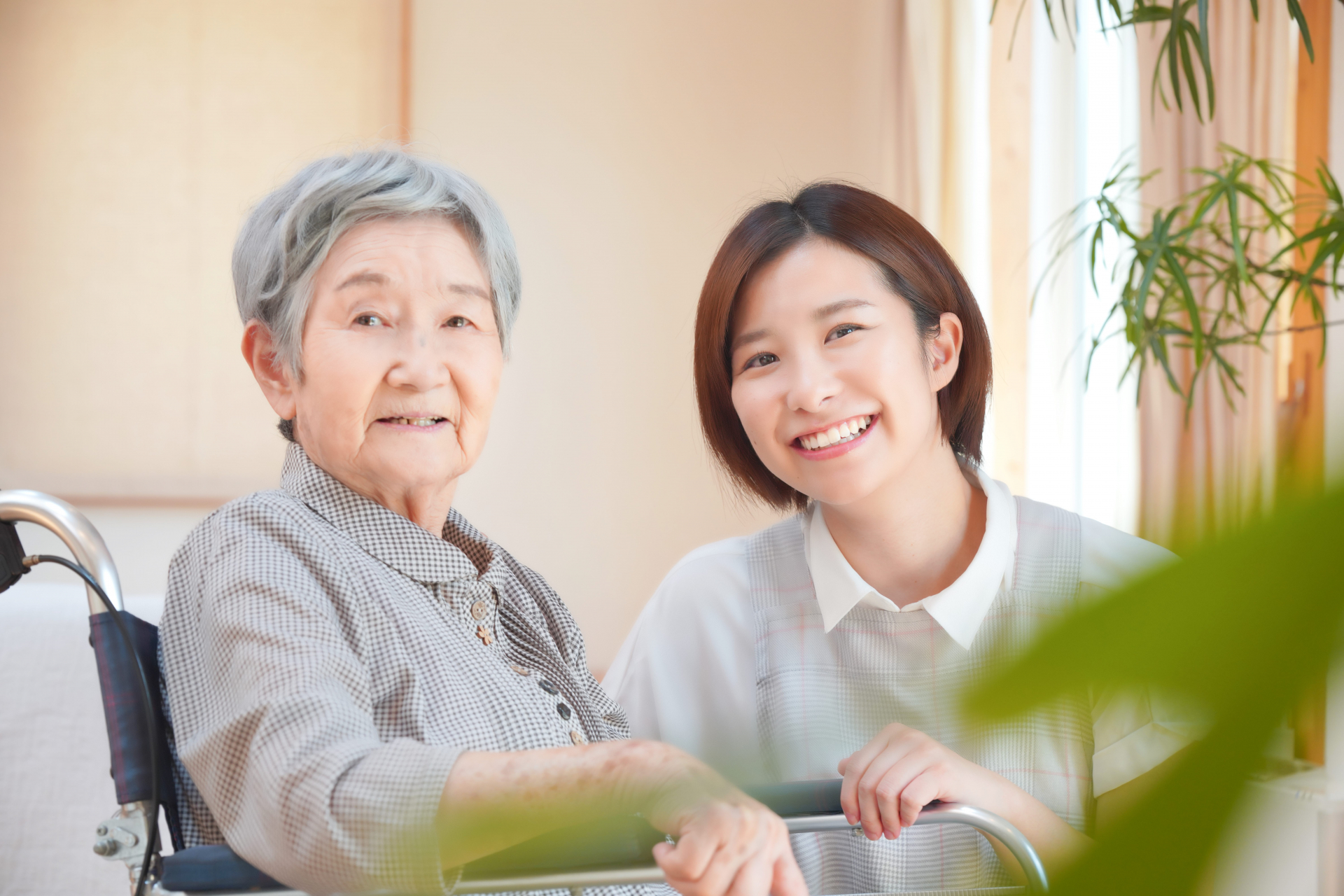 車椅子の女性と笑顔の介護士