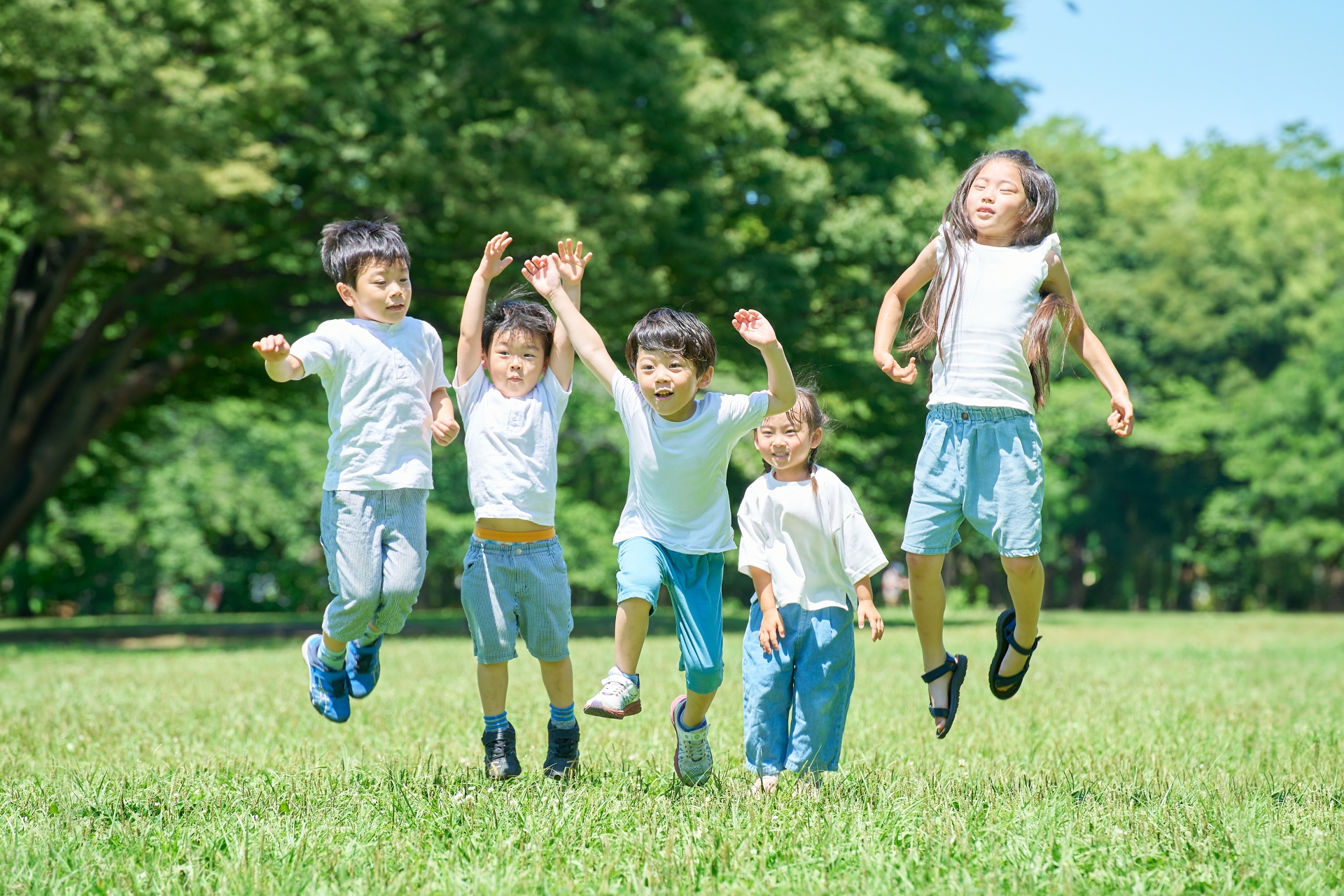 原っぱで飛び跳ねる子供たち