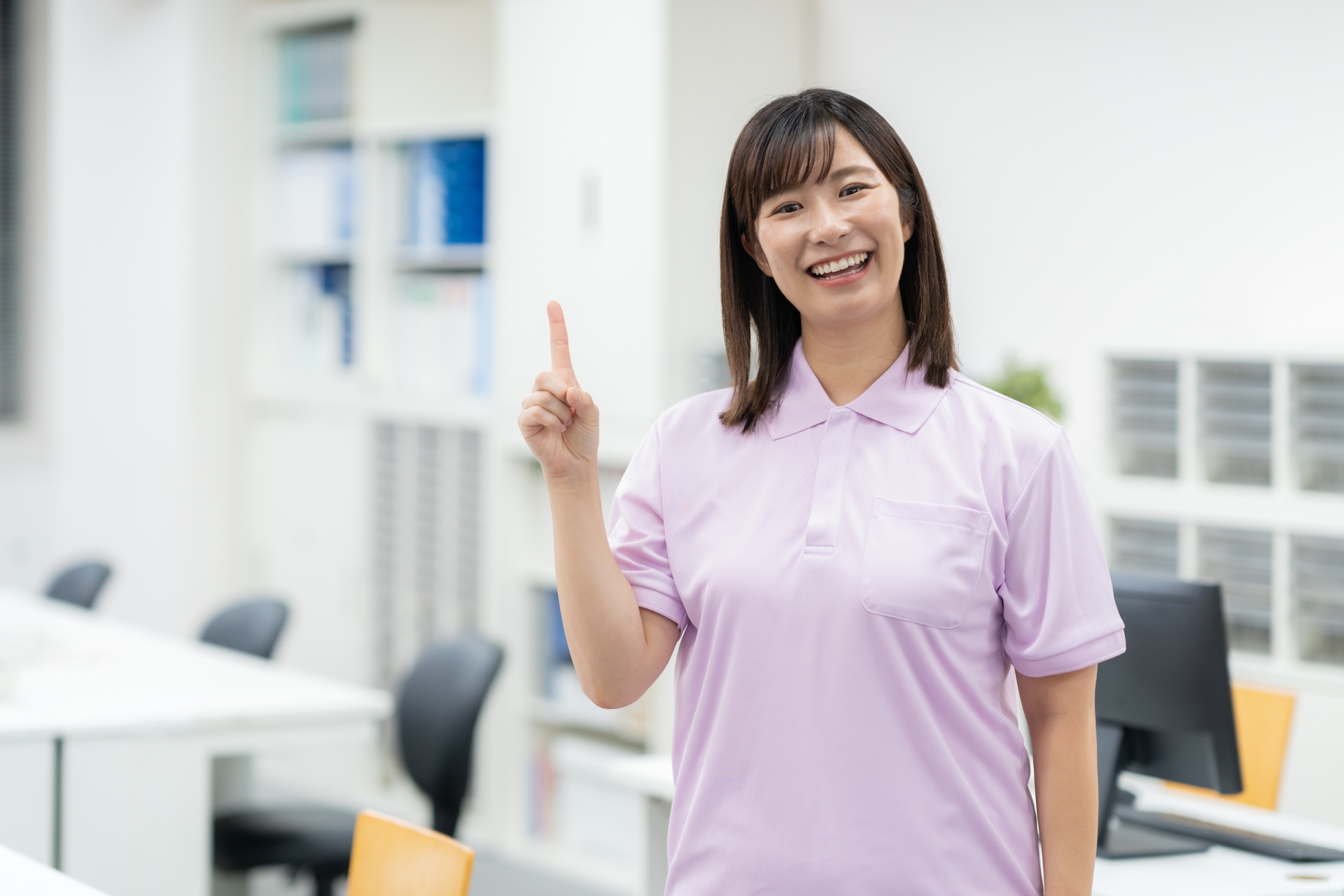 人差し指を立てる笑顔の介護スタッフ