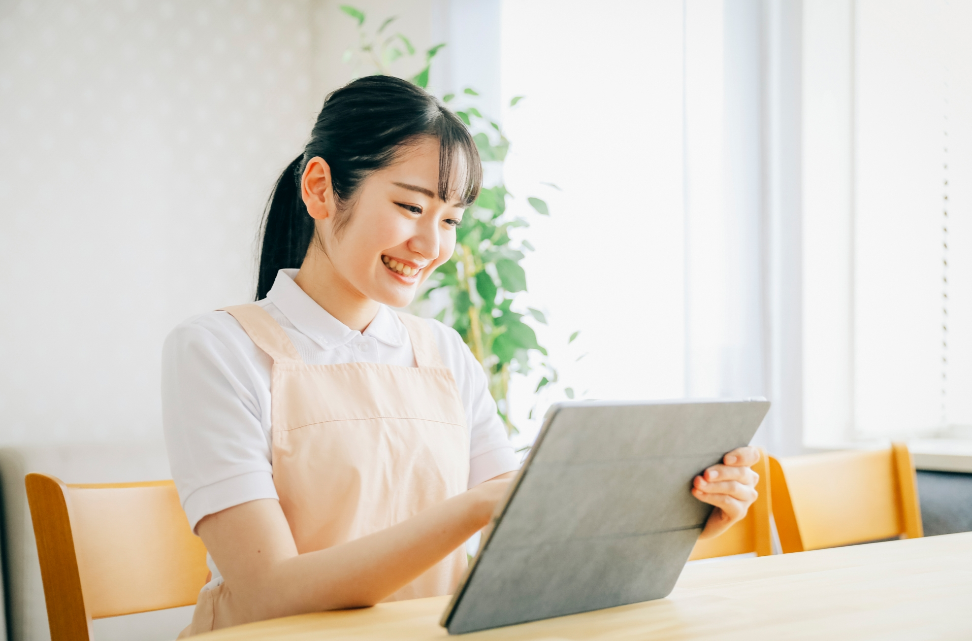 タブレットを操作する女性スタッフ