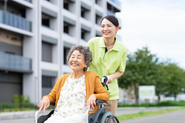 屋外で車椅子を押す介護士