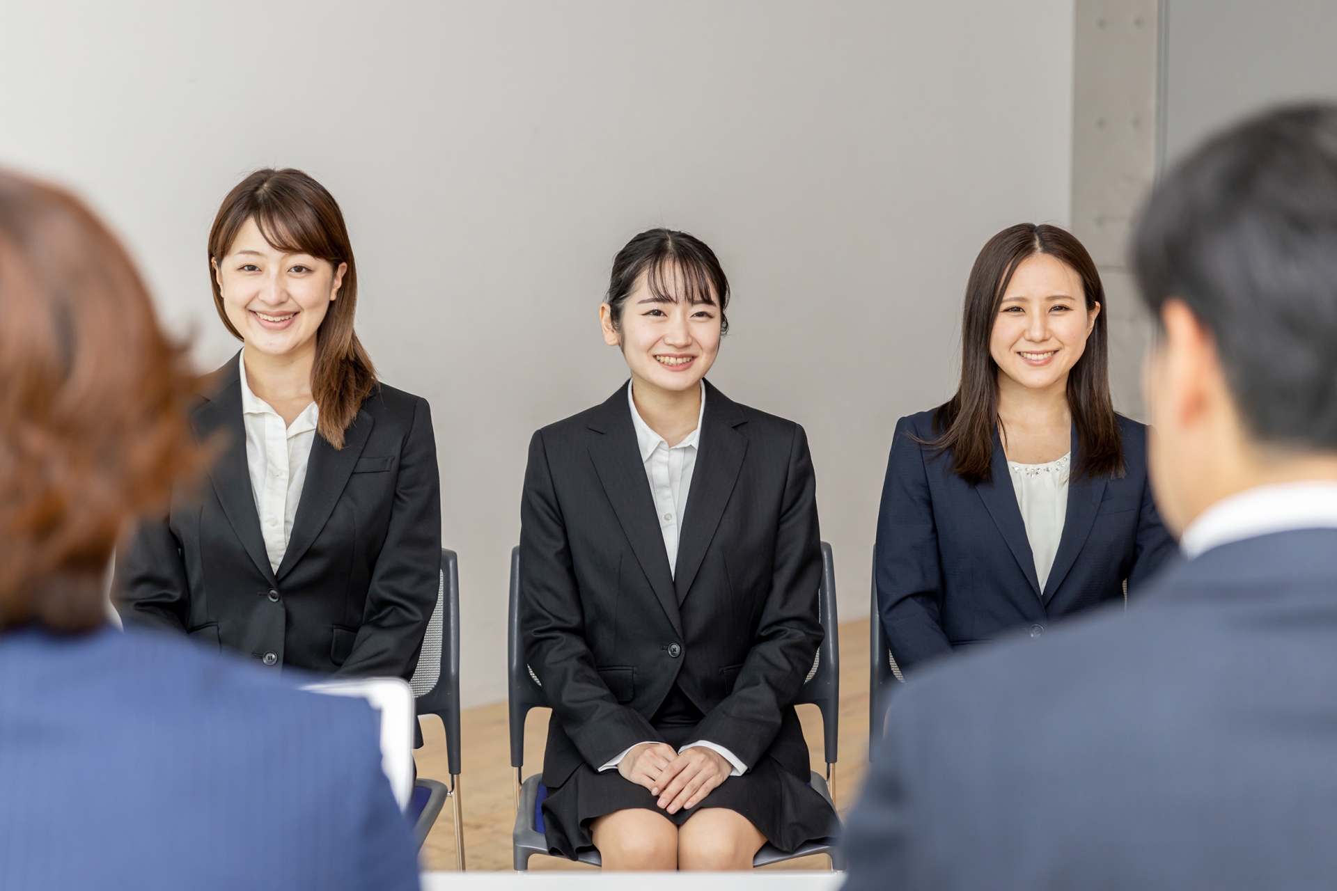 集団面接で面接官の話を聞く就活生（笑顔）