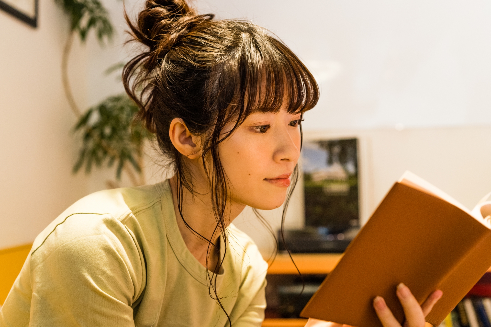 部屋で本を読む女性